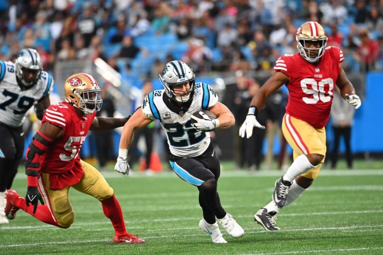 Carolina Panthers running back Christian McCaffrey (22) with the ball as San Francisco 49ers linebacker Dre Greenlaw (57) and defensive tackle Kevin Givens (90) defend in the fourth quarter at Bank of America Stadium.