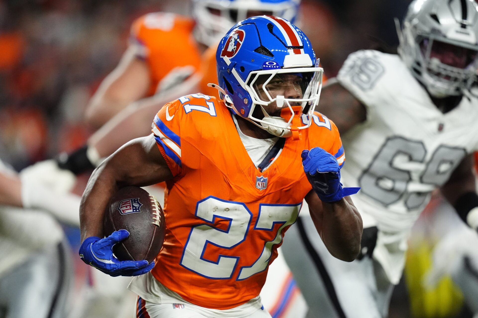 Denver Broncos running back J.K. Dobbins (27) rushes the ball against the Las Vegas Raiders during the first half at Empower Field at Mile High.