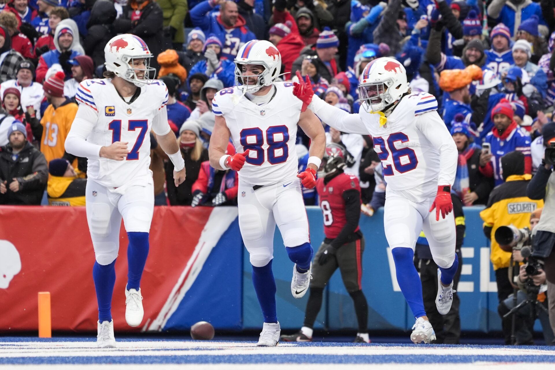 Buffalo Bills running back Ty Johnson (26) celebrates his touchdown against the Tampa Bay Buccaneers with teammates quarterback Josh Allen (17) and tight end Dawson Knox (88) during the first half of the game at Highmark Stadium.