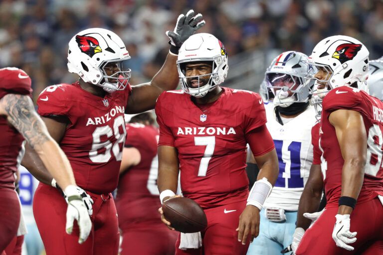 Arizona Cardinals quarterback Jacoby Brissett (7) celebrates with offensive tackle Kelvin Beachum (68) after scoring a touchdown against the Dallas Cowboys in the first half at AT&T Stadium.