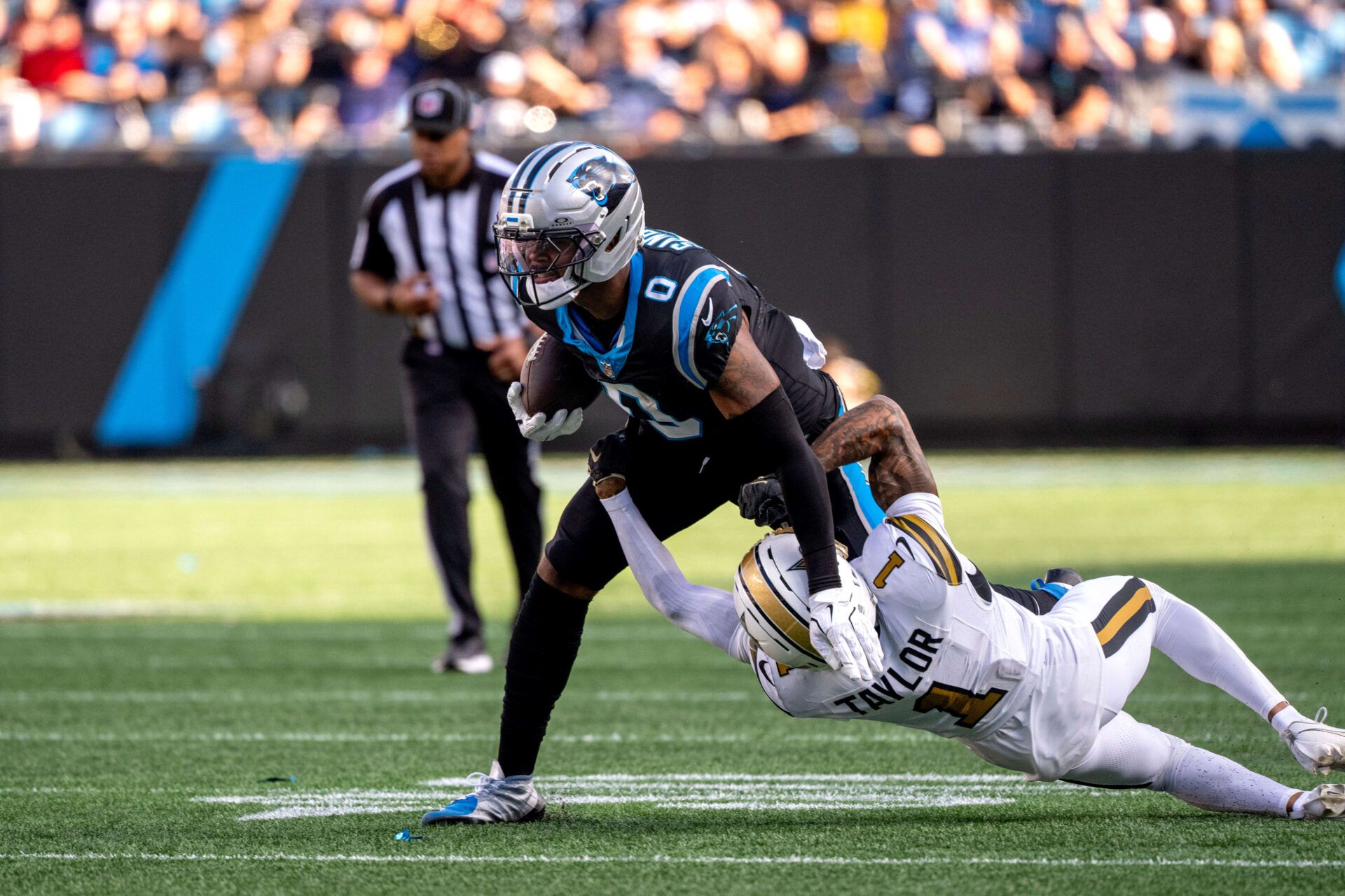 Carolina Panthers tight end Ja'Tavion Sanders (0) with the ball as New Orleans Saints cornerback Alontae Taylor (1) defends in the third quarter at Bank of America Stadium.