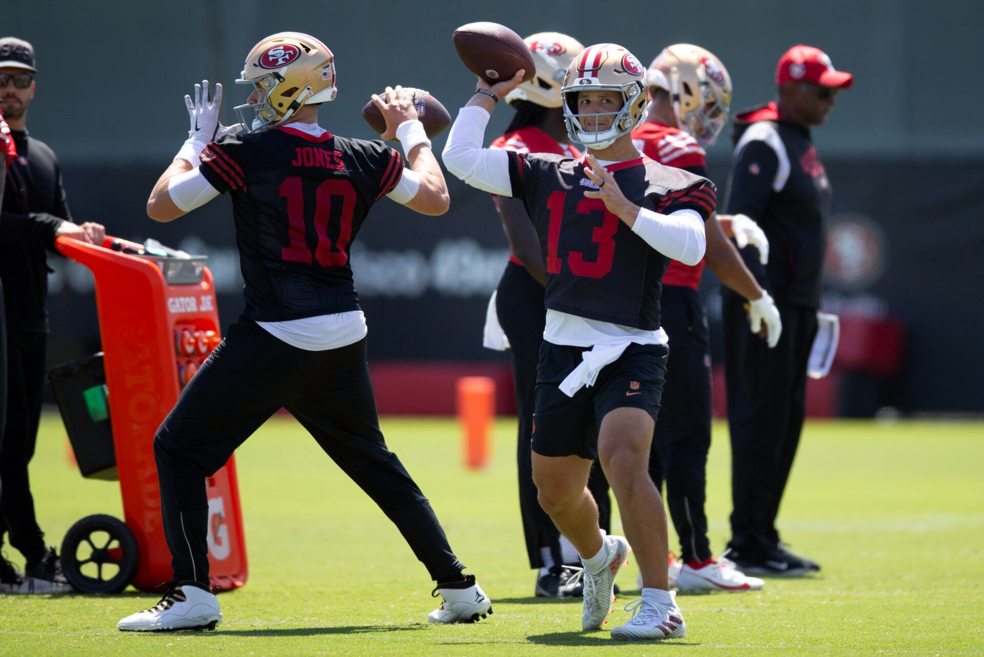 San Francisco 49ers quarterbacks Mac Jones (10) and Brock Purdy (13) work on passing drills during a team OTA at Levi's Stadium.