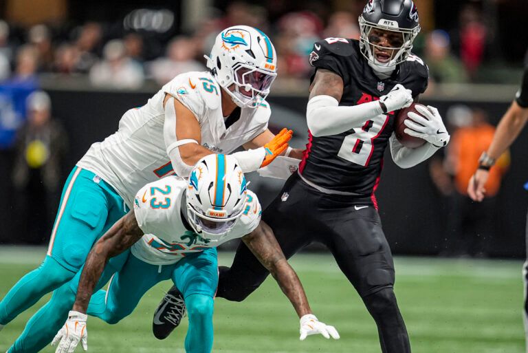 Atlanta Falcons tight end Kyle Pitts Sr. (8) is knocked out of bounds by Miami Dolphins linebacker Jaelan Phillips (15) and cornerback Jack Jones (23) during the first half at Mercedes-Benz Stadium.
