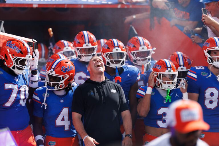 Florida Gators head coach Billy Napier screams while surrounded by his team before a game against the South Florida Bulls at Ben Hill Griffin Stadium.