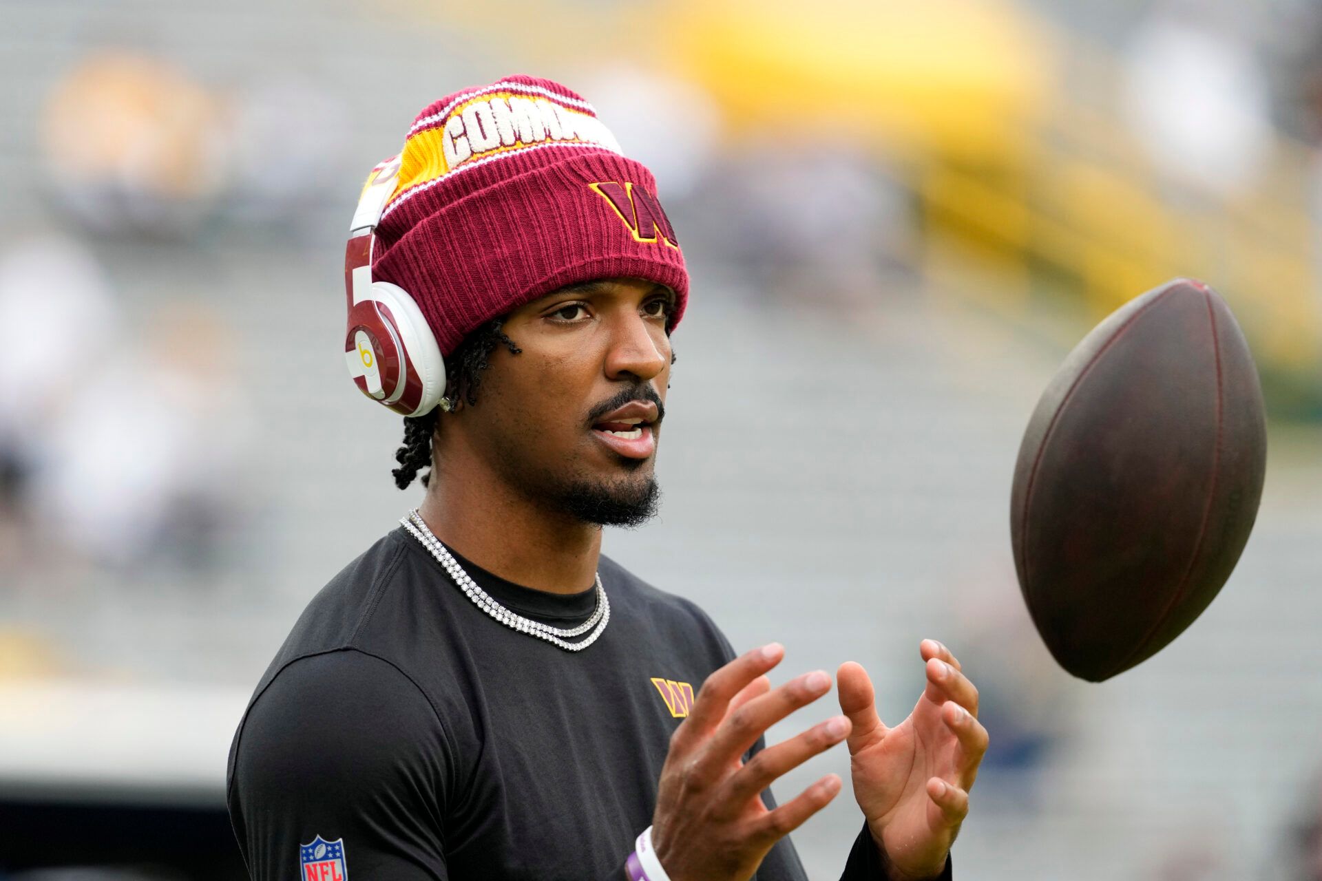 Washington Commanders quarterback Jayden Daniels (5) warms up before a game against the Green Bay Packers at Lambeau Field.
