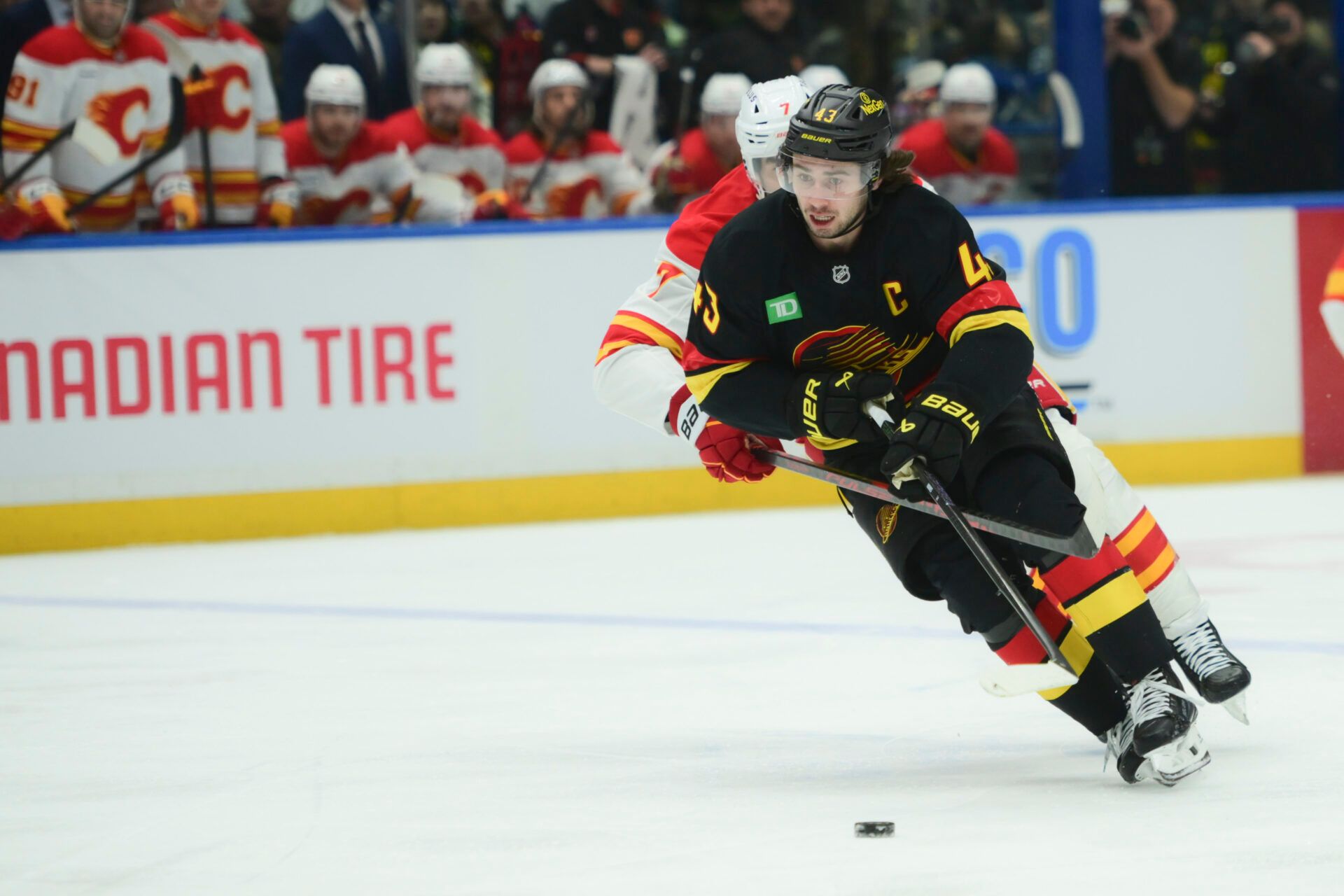 Vancouver Canucks defenseman Quinn Hughes (43) carries the puck against Calgary Flames during the first period at Rogers Arena.