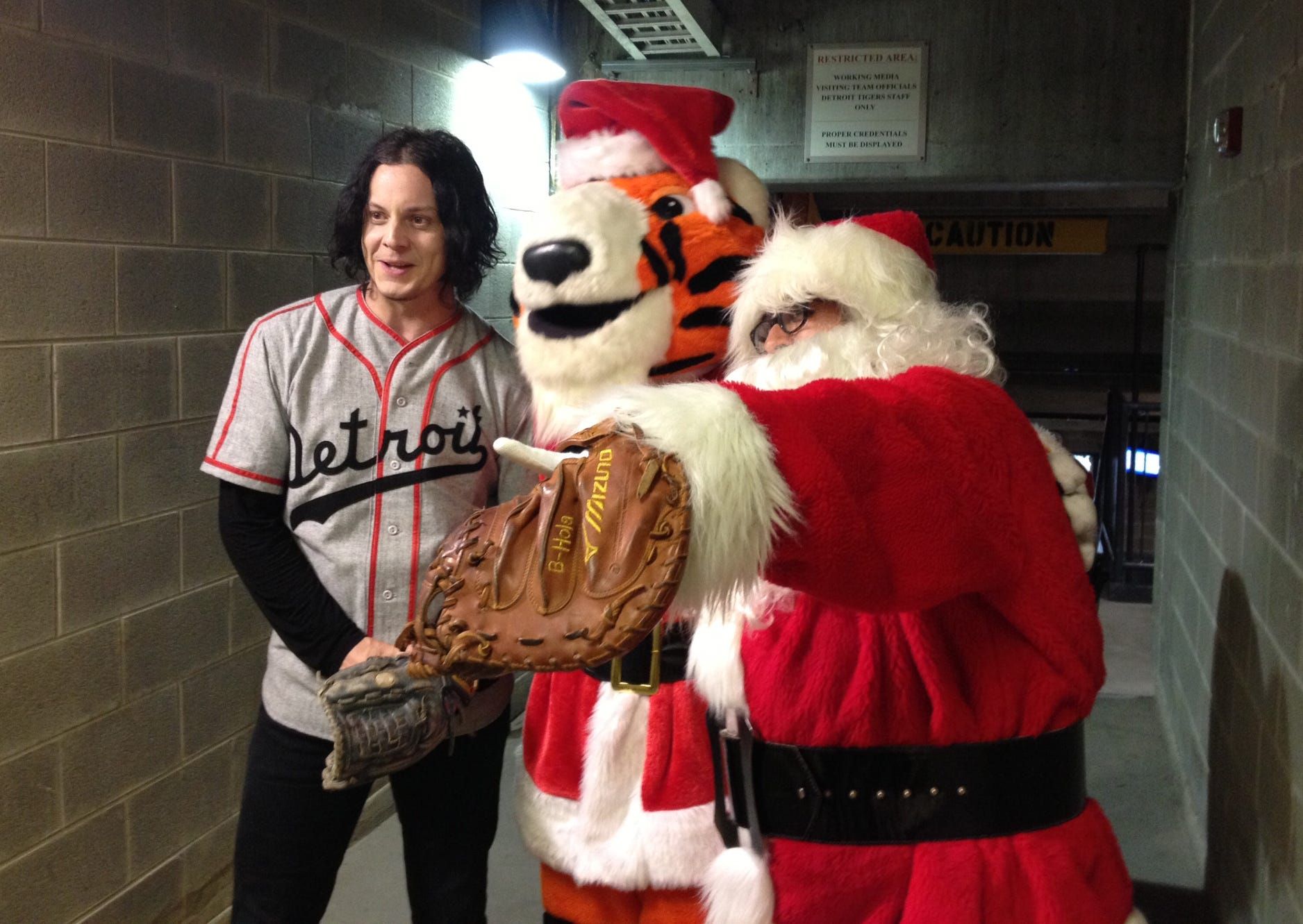 Jack White (with Detroit Tigers mascot Paws and Santa Claus) just before throwing out the ceremonial first pitch at Tuesday, July 29, 2014 Tigers game at Comerica Park in downtown Detroit. It was Christmas in July night at the ballpark, and Santa caught rocker White's pitch.