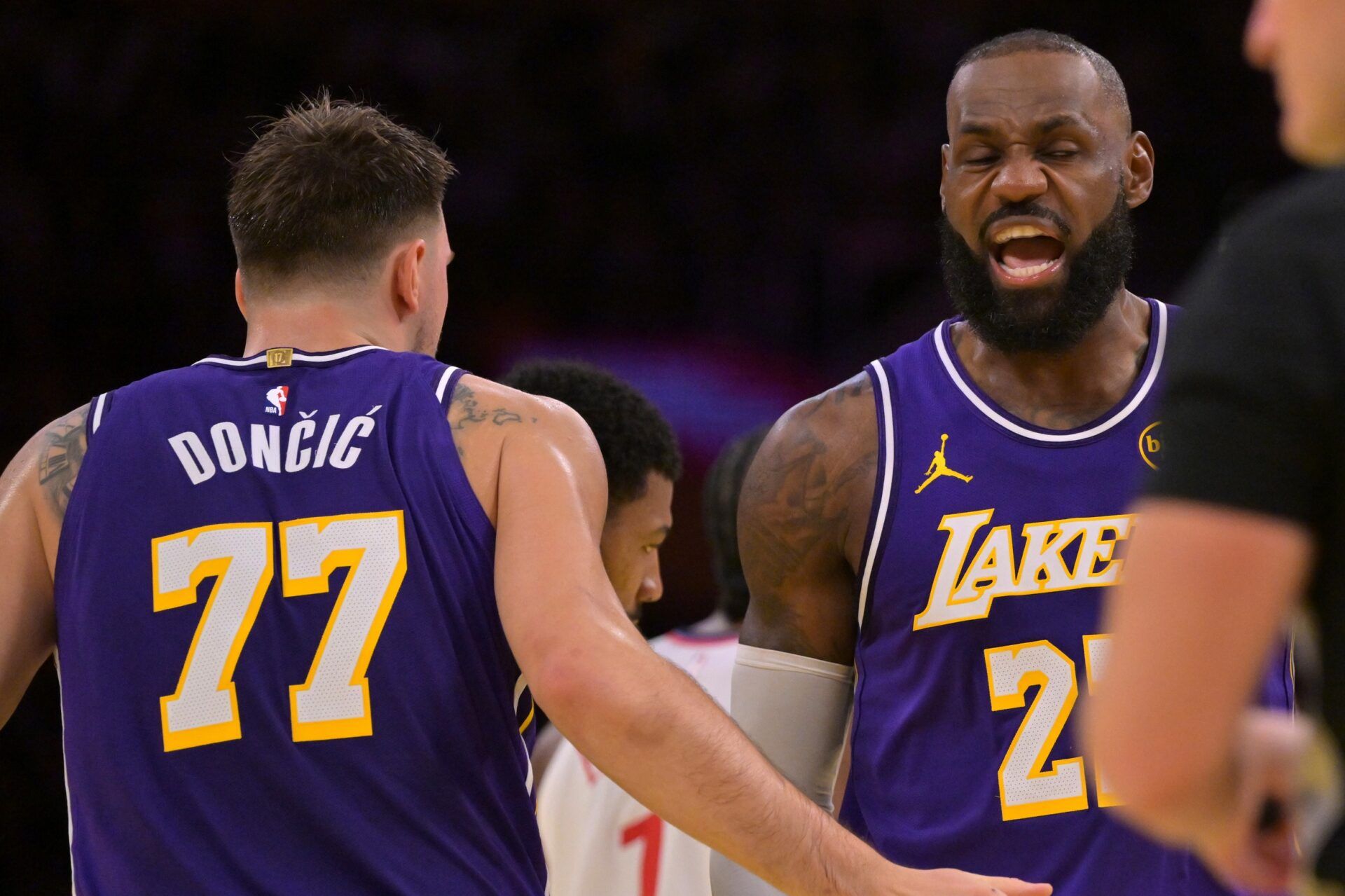 Los Angeles Lakers guard Luka Doncic (77) and forward LeBron James (23) react after a foul during the first half against the Los Angeles Clippers at Crypto.com Arena.