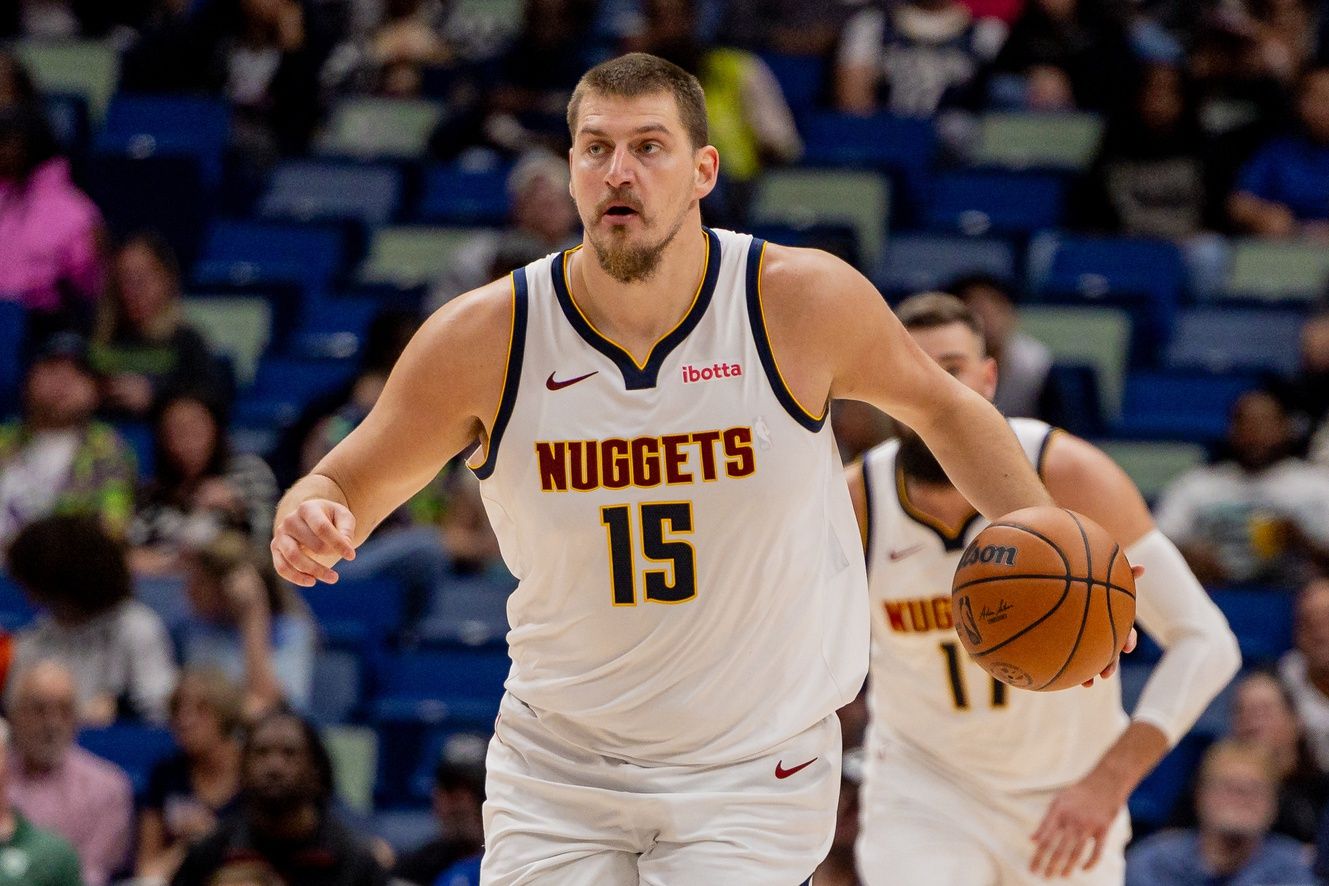 Denver Nuggets center Nikola Jokić (15) brings the ball up court against the New Orleans Pelicans during the first half  at Smoothie King Center.