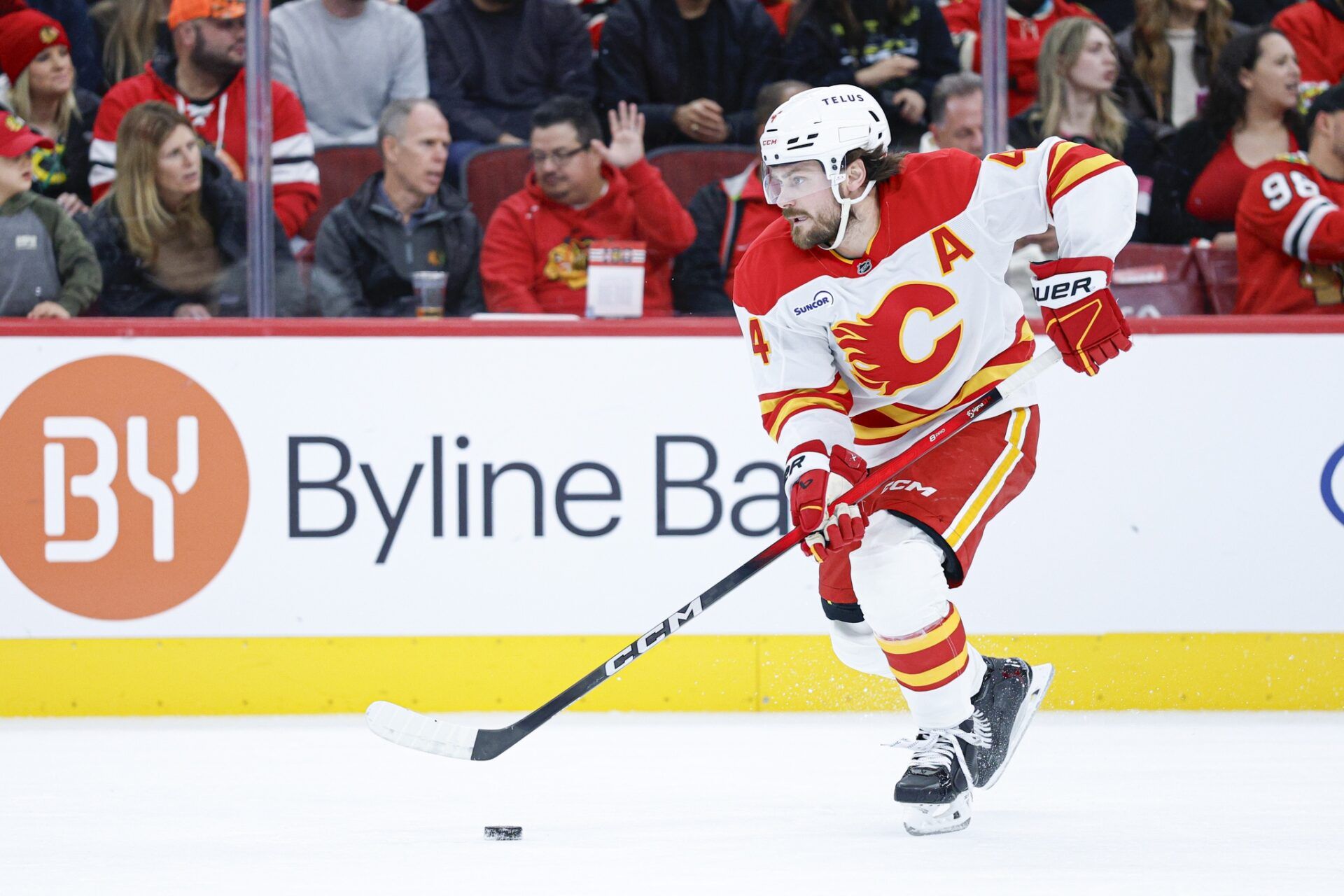 Calgary Flames defenseman Rasmus Andersson (4) controls the puck during the second period of NHL game against the Chicago Blackhawks  at United Center.