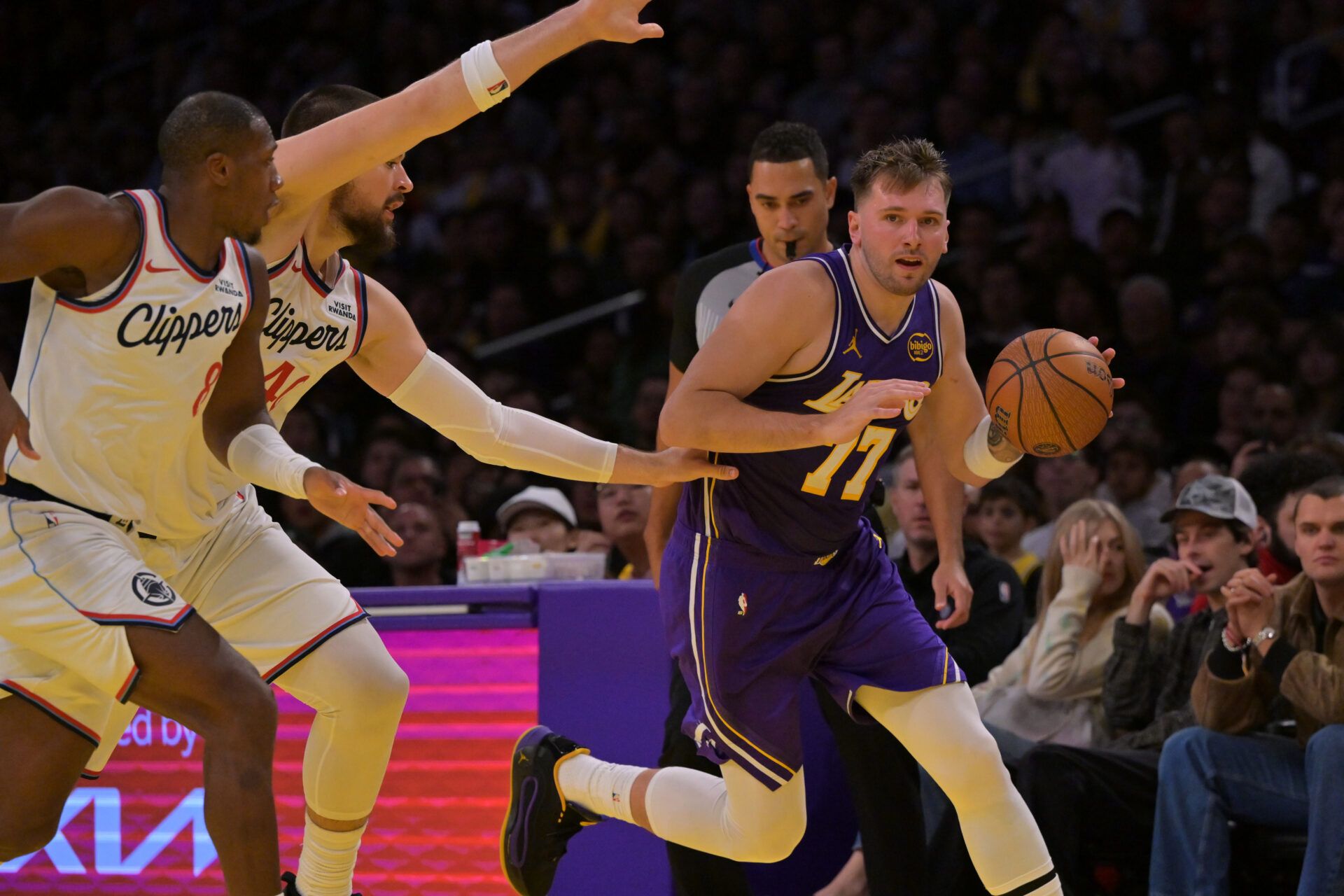 Los Angeles Lakers guard Luka Doncic (77) drives past Los Angeles Clippers guard Kris Dunn (8) and center Ivica Zubac (40) during the first half at Crypto.com Arena.