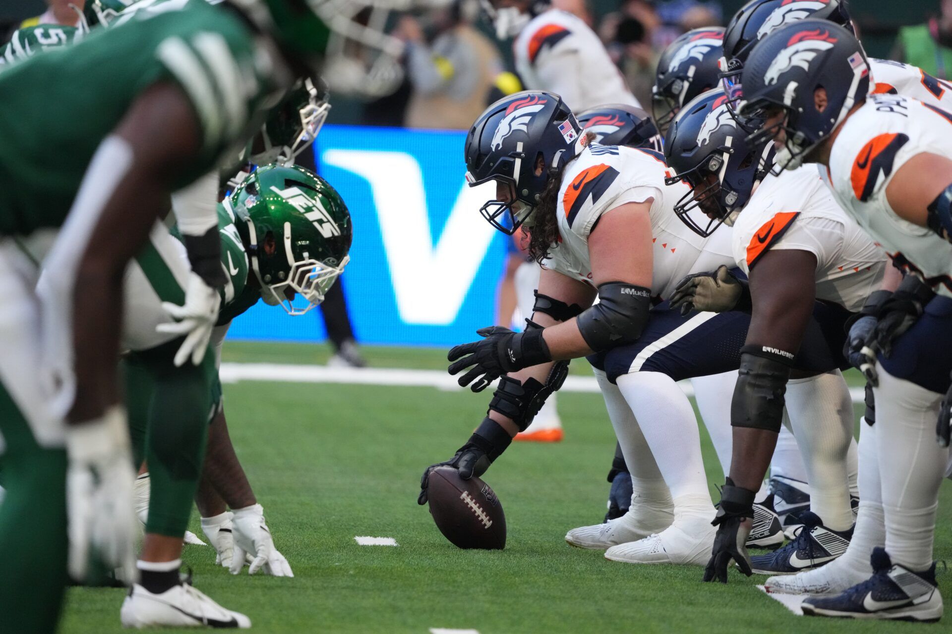 Helmets at the line of scrimmage as Denver Broncos center Luke Wattenberg (60) snaps the ball against the New York Jets during an NFL International Series game at Tottenham Hotspur Stadium.