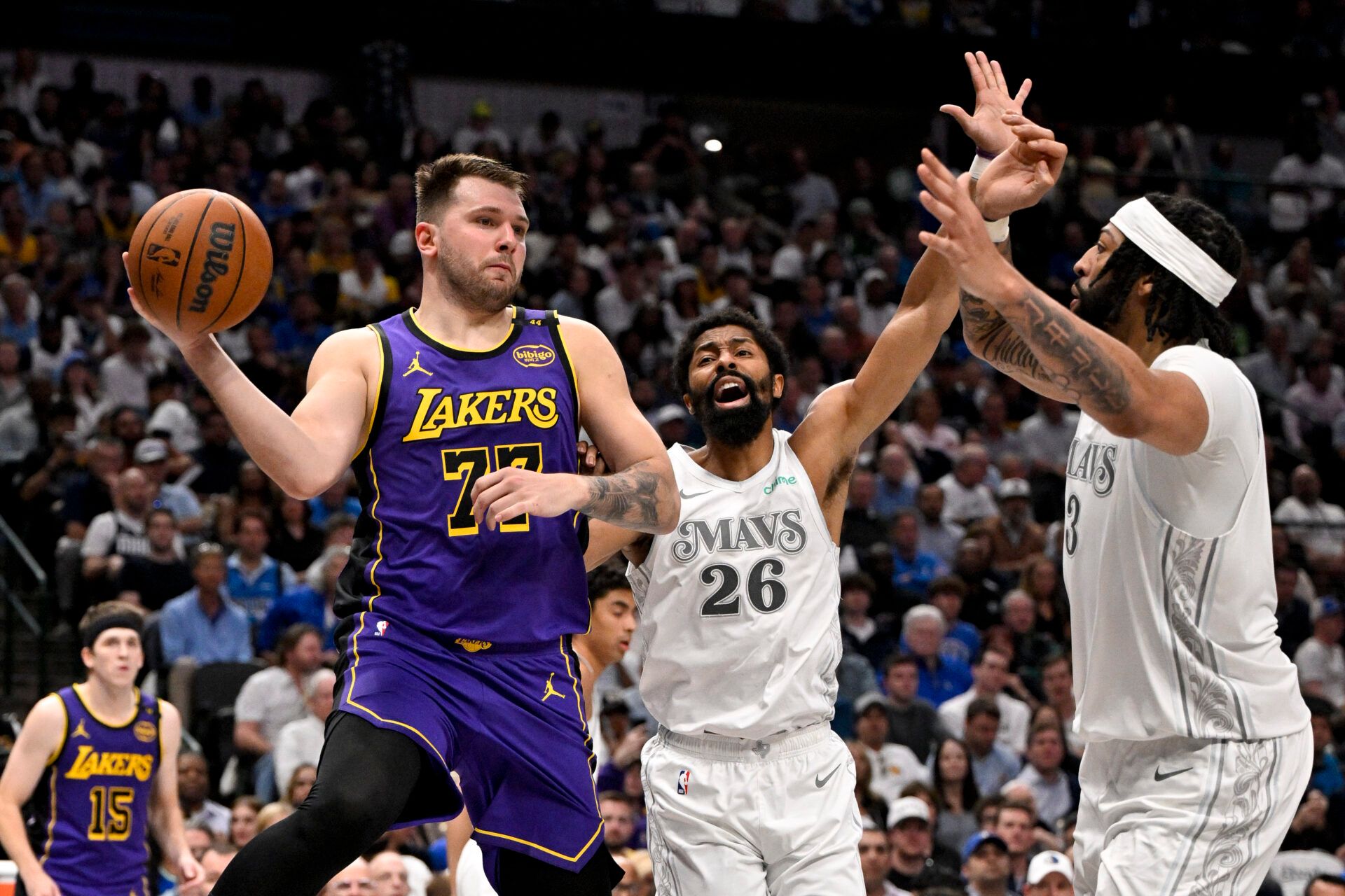 Los Angeles Lakers guard Luka Doncic (77) passes the ball by Dallas Mavericks guard Spencer Dinwiddie (26) and forward Anthony Davis (3) during the third quarter at the American Airlines Center.