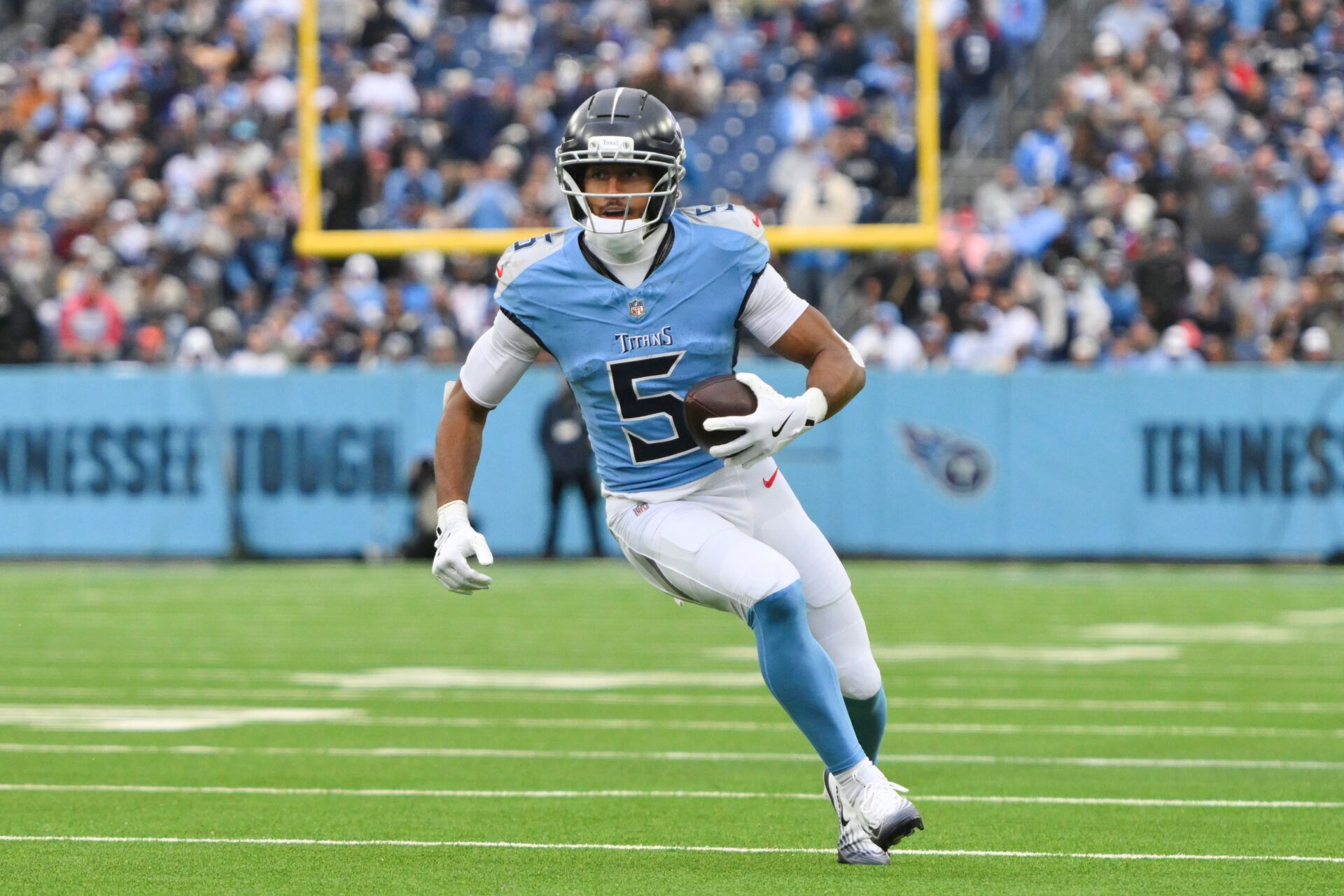 Tennessee Titans wide receiver Elic Ayomanor (5) runs the ball after a catch against the Los Angeles Chargers during the third quarter at Nissan Stadium.