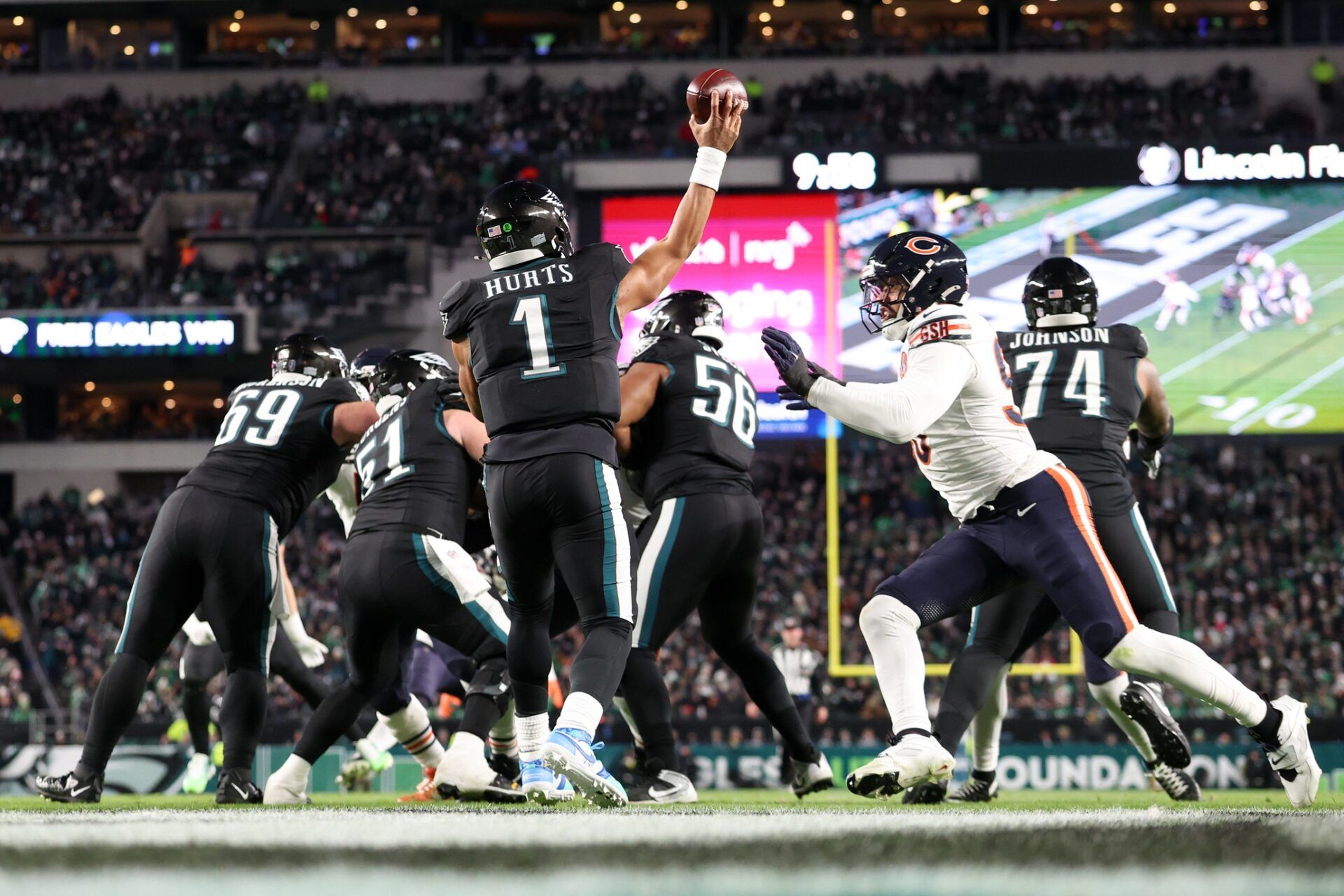 Philadelphia Eagles quarterback Jalen Hurts (1) passes the ball under pressure by Chicago Bears defensive end Montez Sweat (98) during the third quarter of the game at Lincoln Financial Field.
