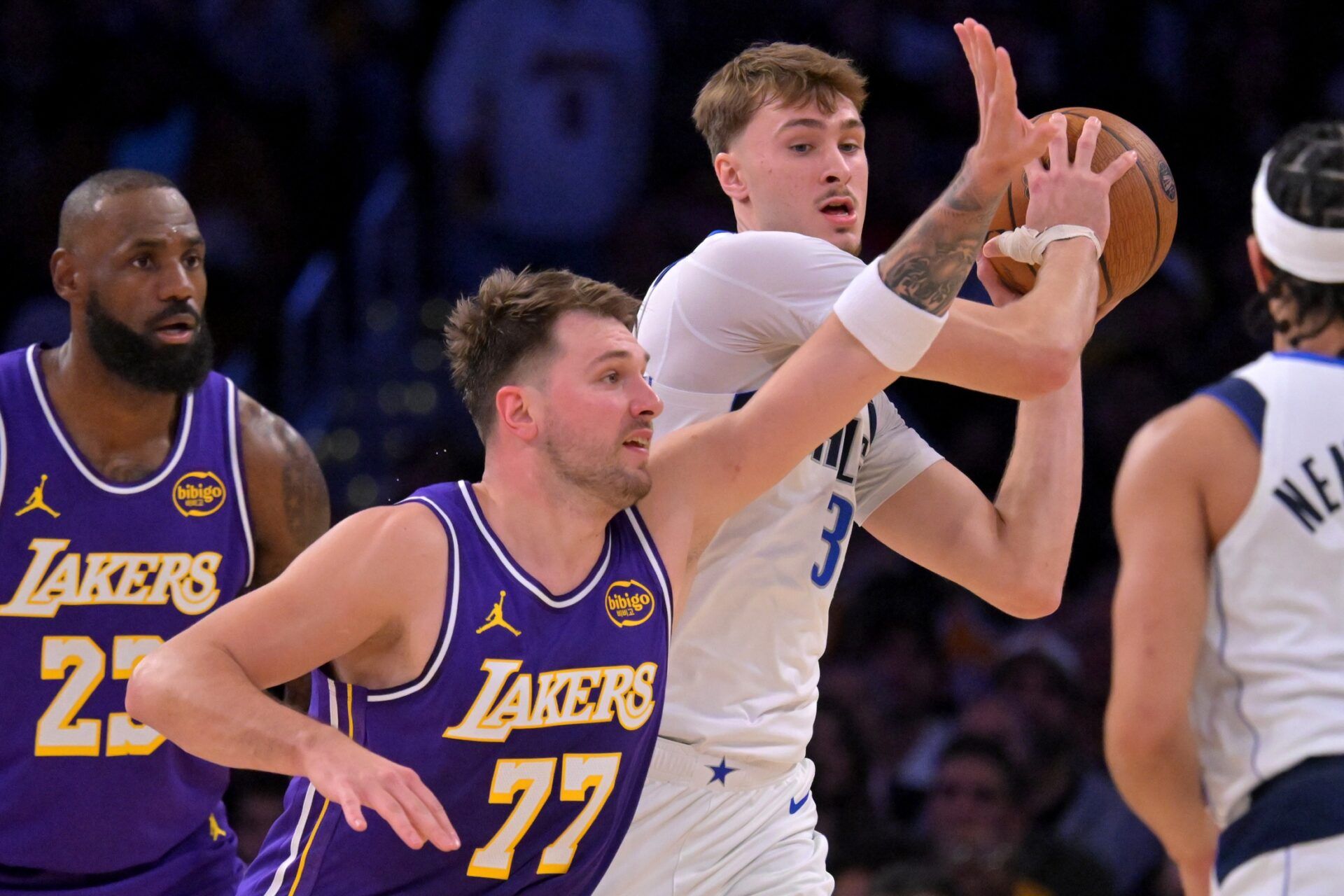 Dallas Mavericks forward Cooper Flagg (32) is defended by Los Angeles Lakers guard Luka Doncic (77) in the first half at Crypto.com Arena.