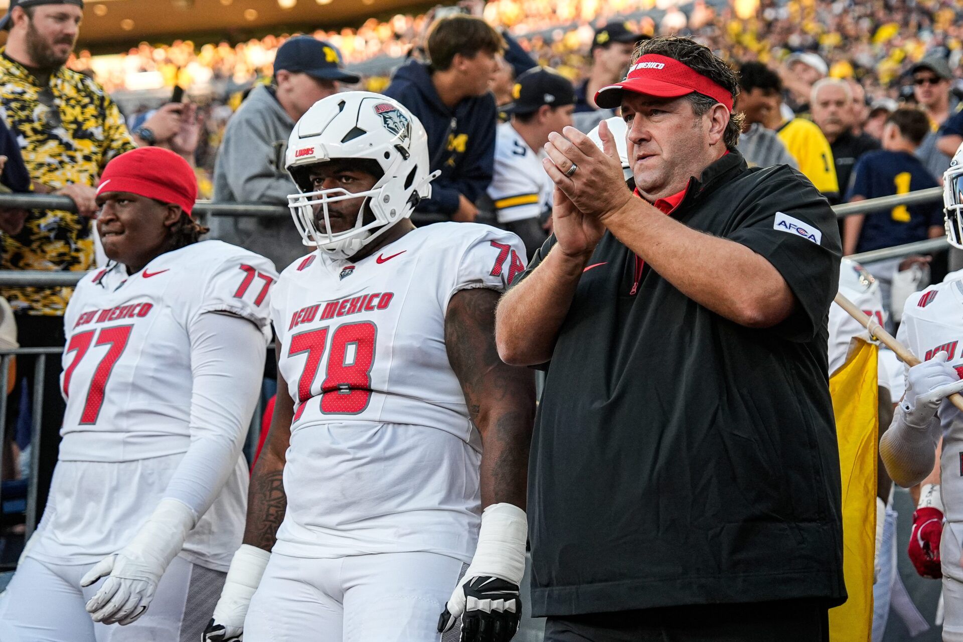 New Mexico head coach Jason Eck and players take the field against Michigan at Michigan Stadium in Ann Arbor on Saturday, August 30, 2025.