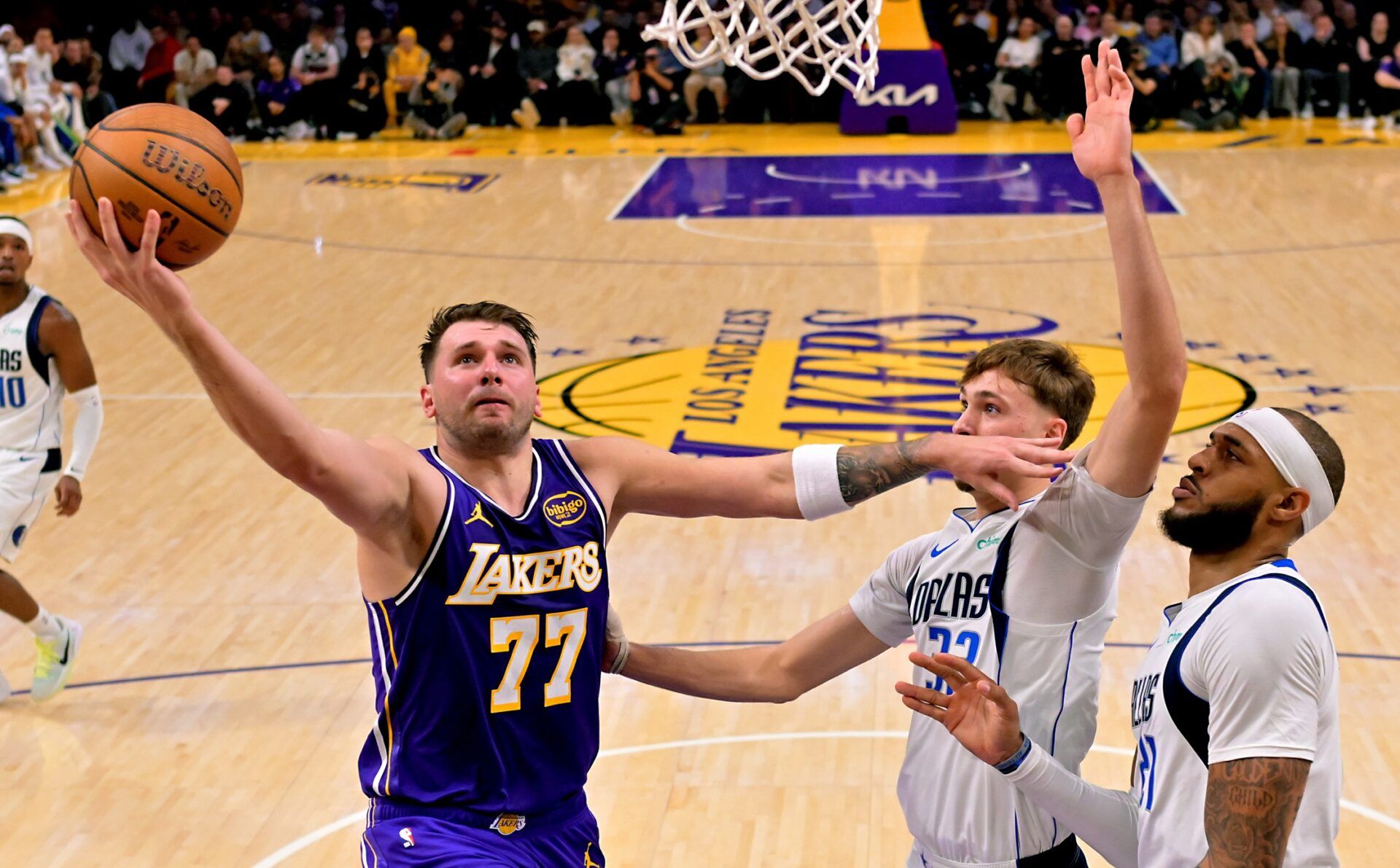 Los Angeles Lakers guard Luka Doncic (77) drives past Dallas Mavericks forward Cooper Flagg (32) and forward Daniel Gafford (21) in the first half at Crypto.com Arena.