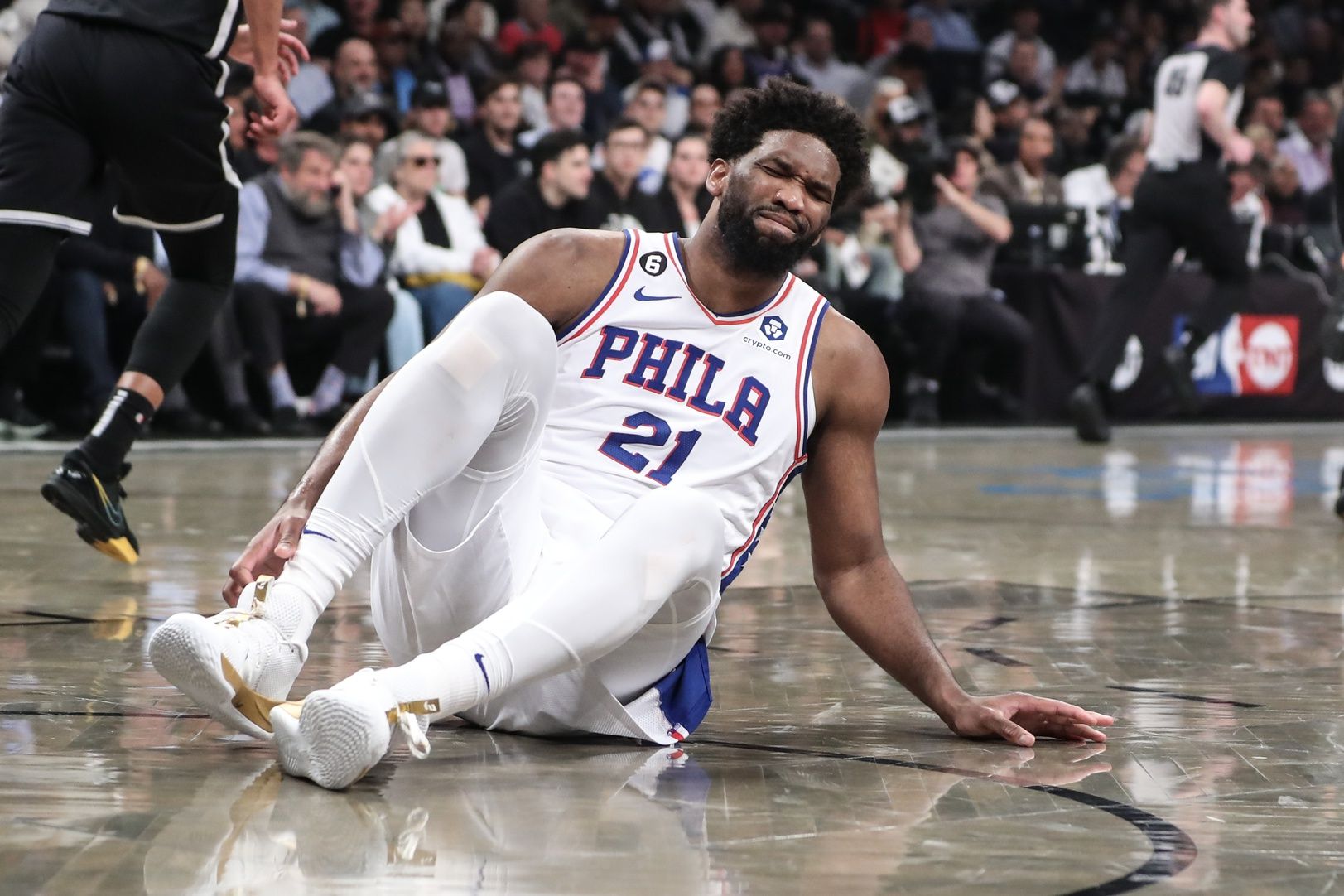 Philadelphia 76ers center Joel Embiid (21) grimaces after falling to the floor during game three of the 2023 NBA playoffs against the Brooklyn Nets at Barclays Center.