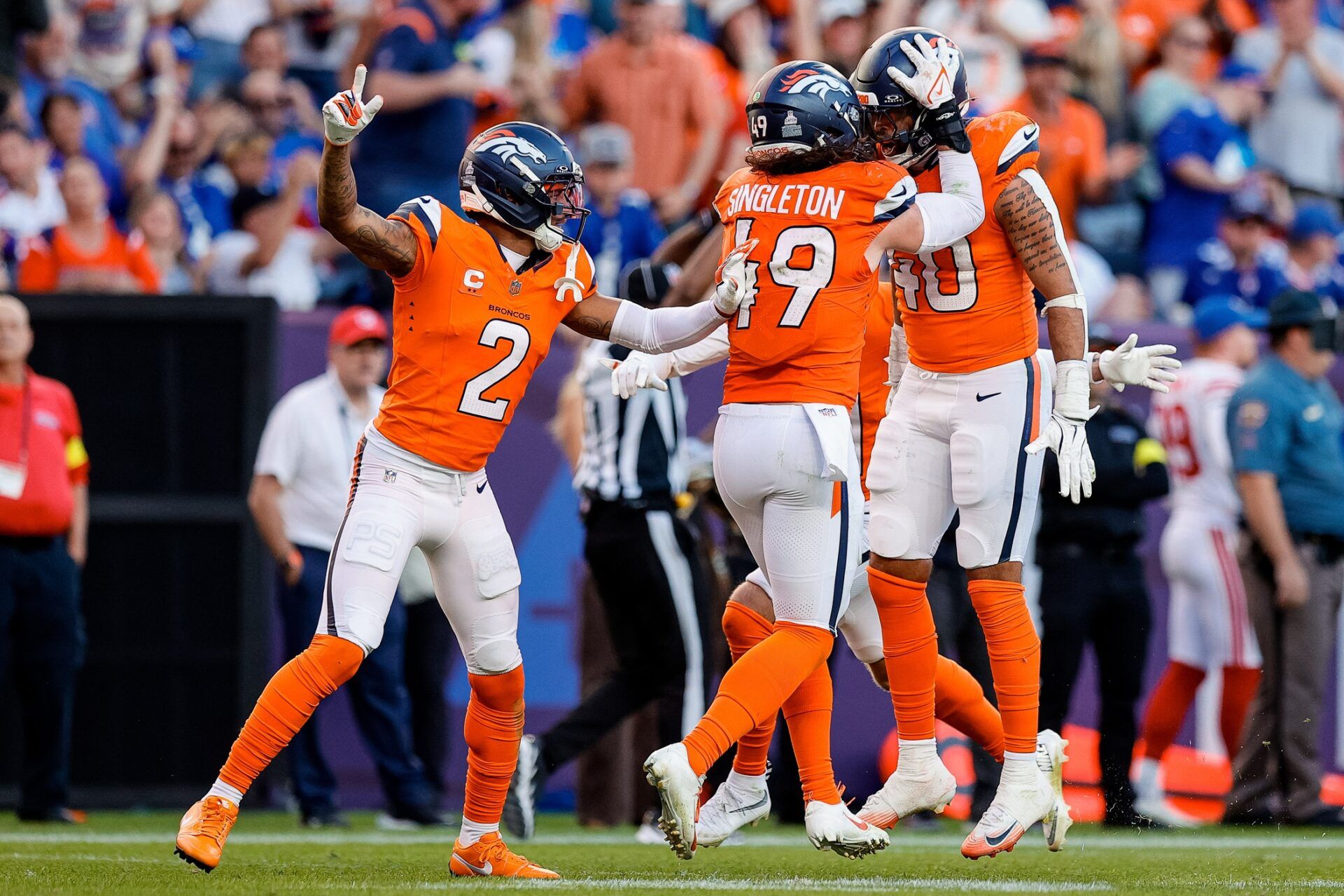 Denver Broncos linebacker Justin Strnad (40) celebrates his interception with linebacker Alex Singleton (49) and cornerback Pat Surtain II (2) in the fourth quarter against the New York Giants at Empower Field at Mile High.