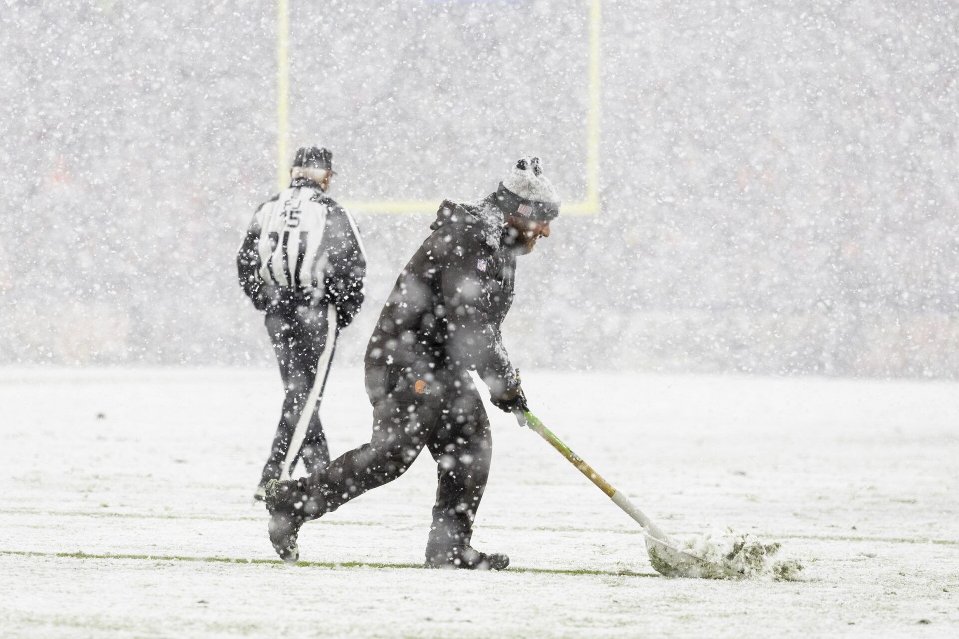 A grounds crew member shovels snow off the yard lines during the third quarter between the Cleveland Browns and the Pittsburgh Steelers at Huntington Bank Field Stadium.
