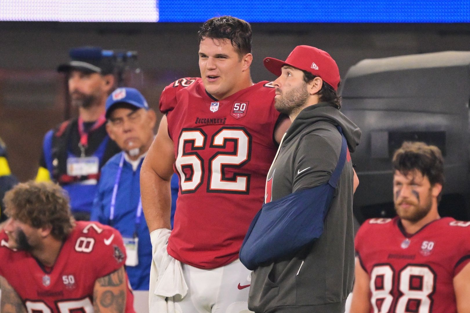 Tampa Bay Buccaneers quarterback Baker Mayfield (6) stands on the sideline with his left arm in a sling and chats with center Graham Barton (62) during the fourth quarter at SoFi Stadium.