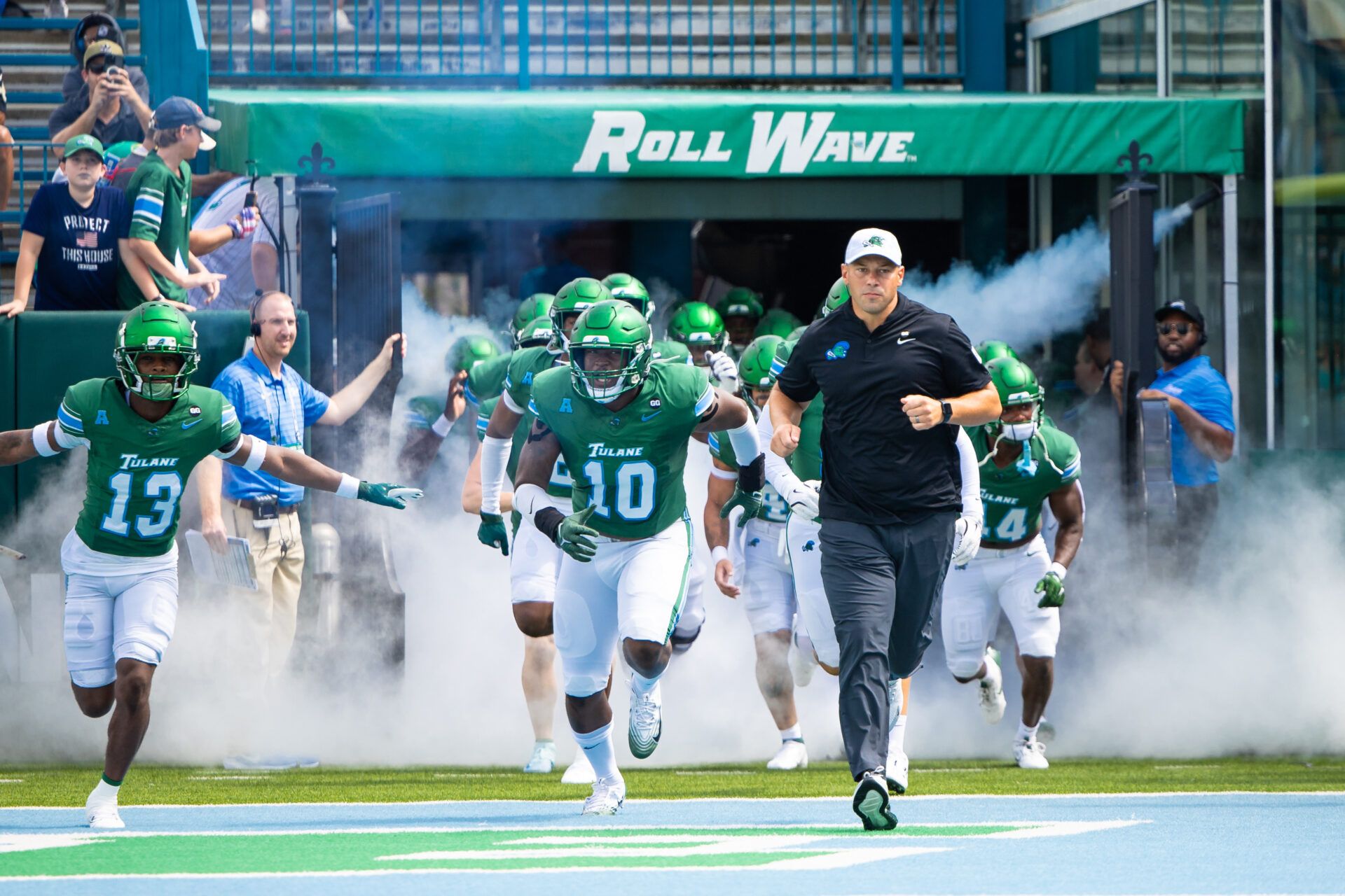 Tulane Green Wave head coach Jon Sumrall runs out the tunnel with defensive end Gerrod Henderson (10) and safety Tavare Smith (13) against Northwestern Wildcats during the first half at Yulman Stadium.