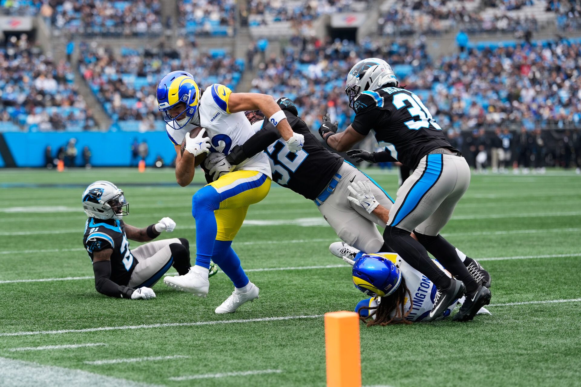 Los Angeles Rams wide receiver Puka Nacua (12) runs after making a catch and is tackled by Carolina Panthers linebacker Trevin Wallace (32) during the first quarter at Bank of America Stadium.