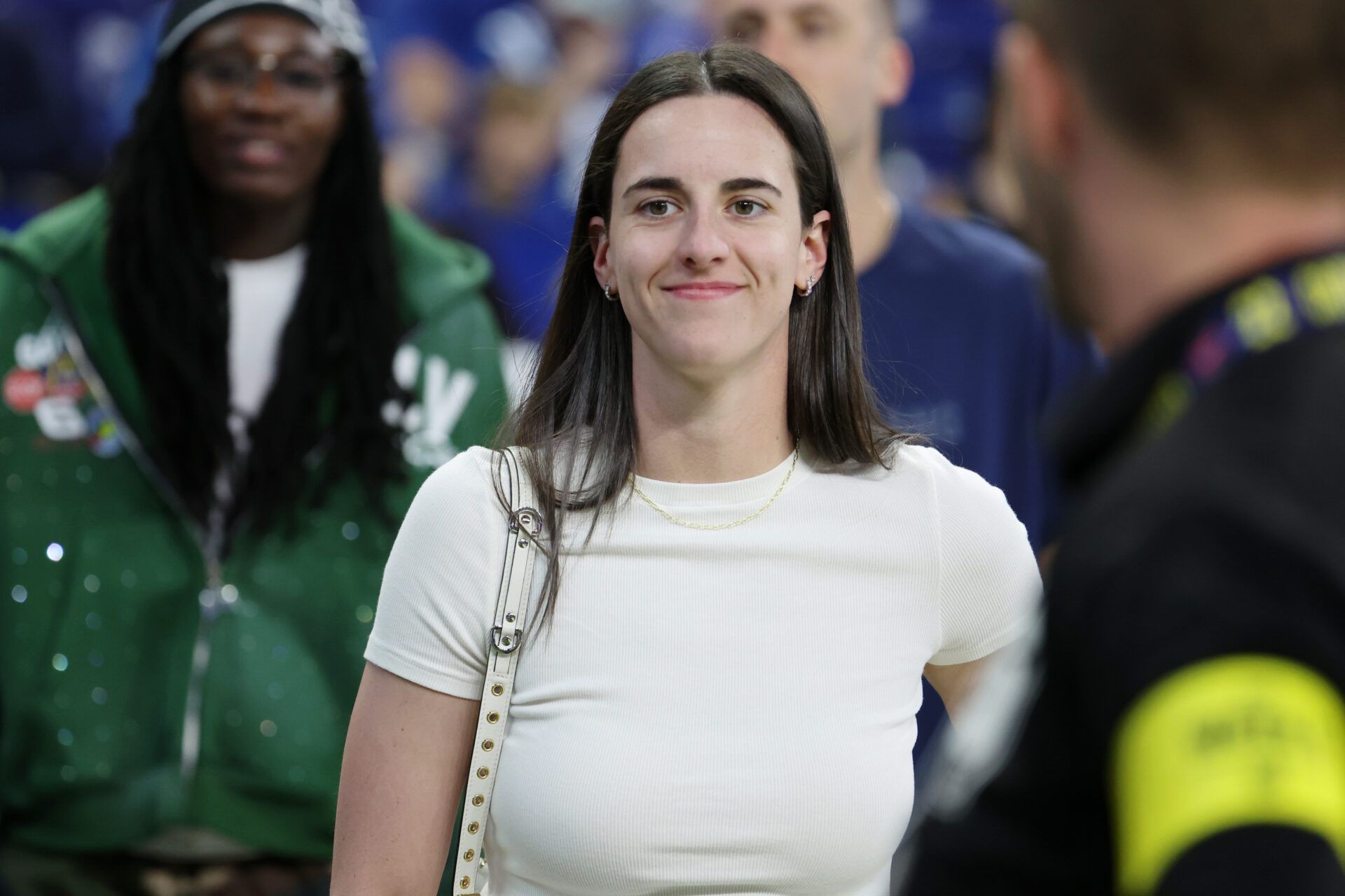 Caitlin Clark looks on from the sideline during warmups before the game between the Las Vegas Raiders and the Indianapolis Colts at Lucas Oil Stadium.