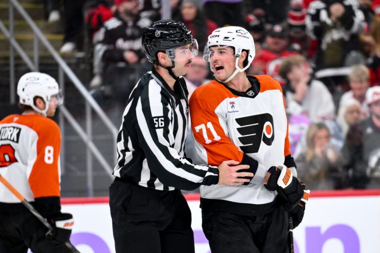Philadelphia Flyers right wing Tyson Foerster (71) is restrained by linesman Julien Fournier (56) during the third period against the New Jersey Devils at Prudential Center.