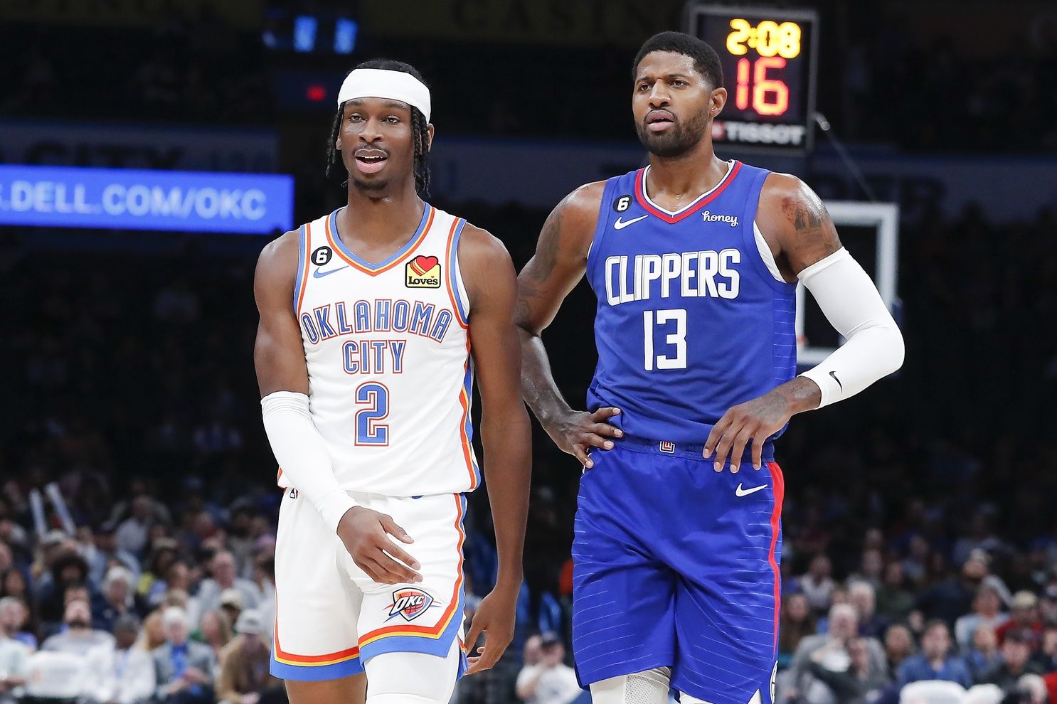Oklahoma City Thunder guard Shai Gilgeous-Alexander (2) and LA Clippers guard Paul George (13) walks down the court during a time out during the first half at Paycom Center.