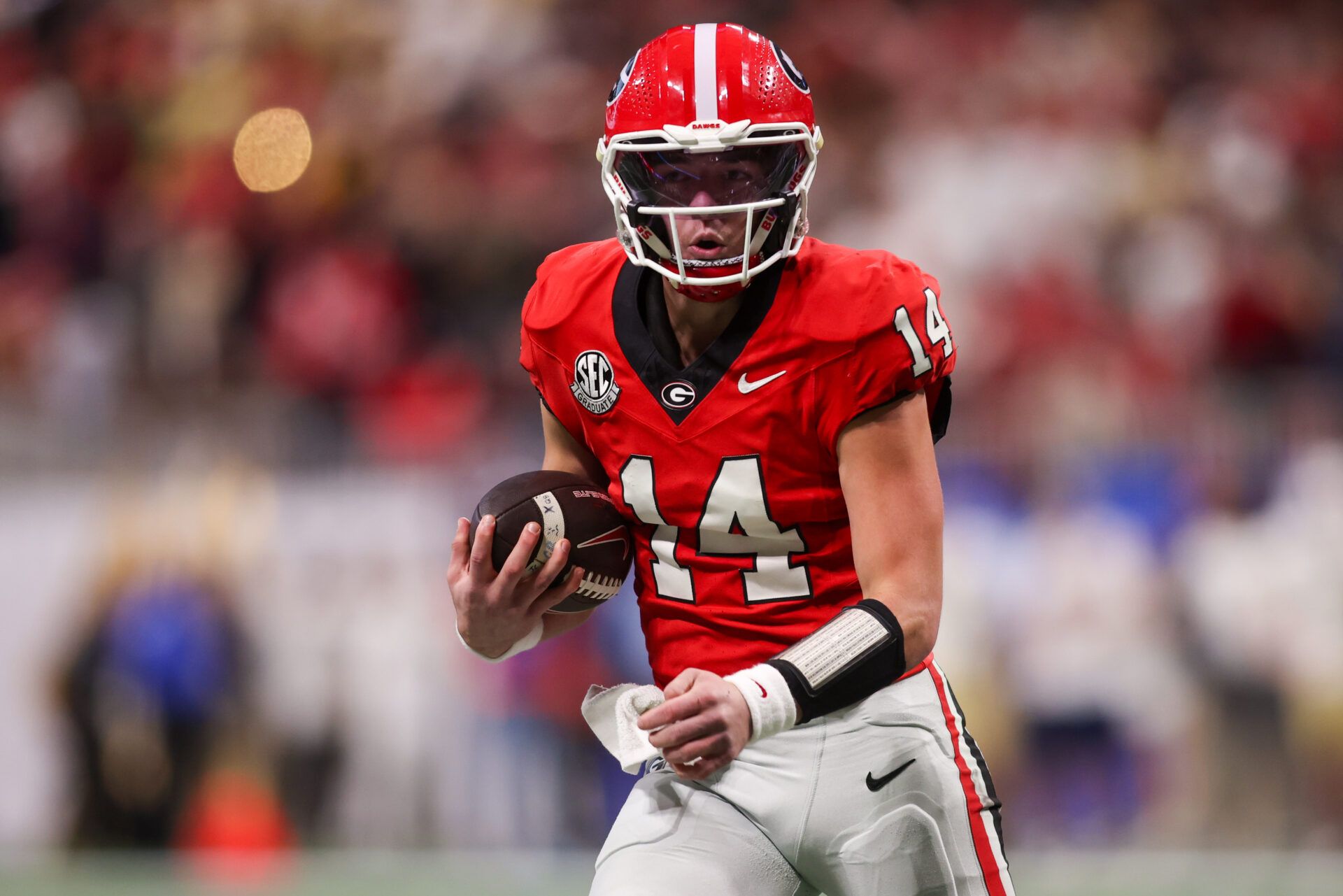 Georgia Bulldogs quarterback Gunner Stockton (14) runs the ball against the Georgia Tech Yellow Jackets in the second quarter at Mercedes-Benz Stadium.