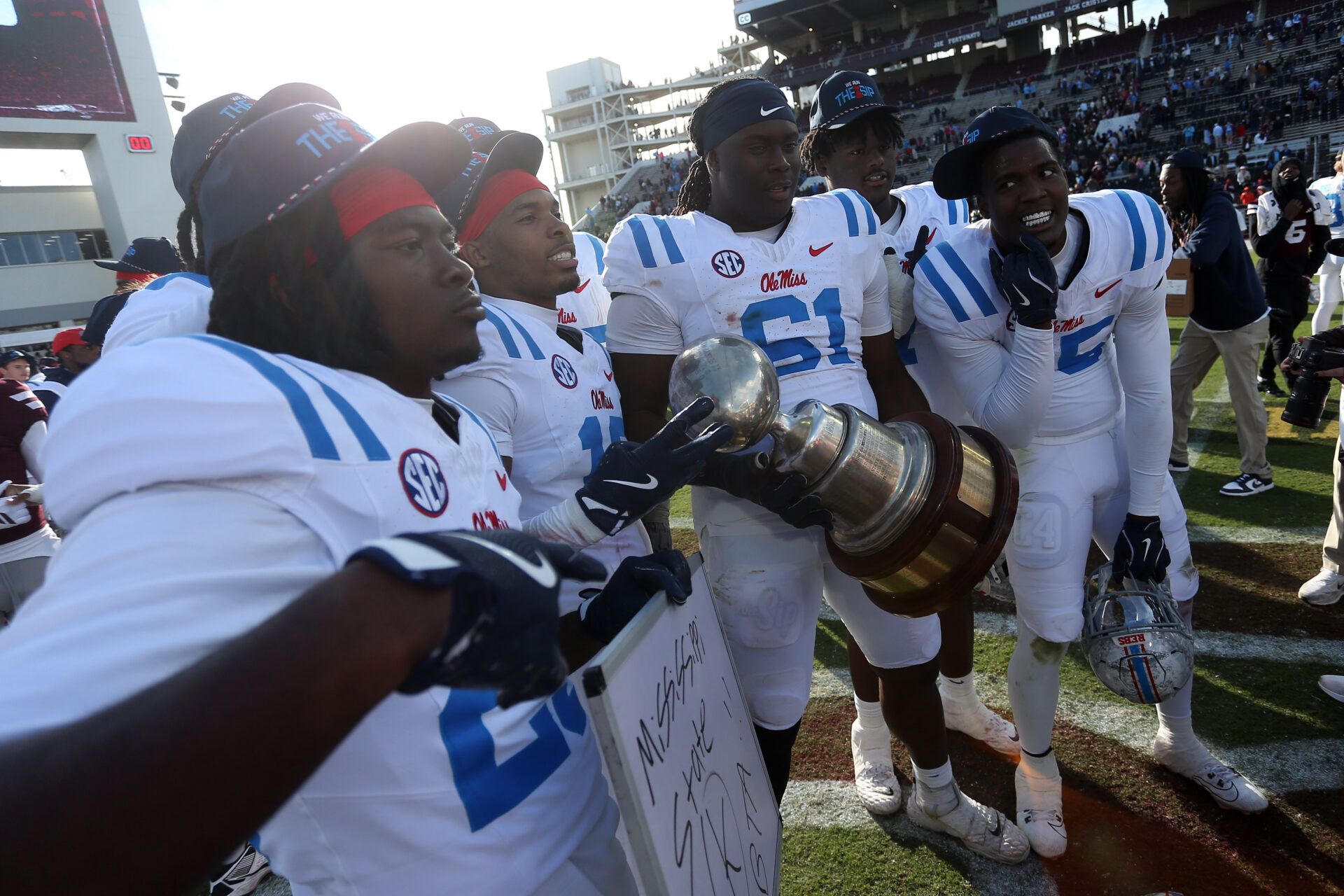 Mississippi Rebels players celebrate with the Golden Egg trophy after defeating the Mississippi State Bulldogs at Davis Wade Stadium at Scott Field.