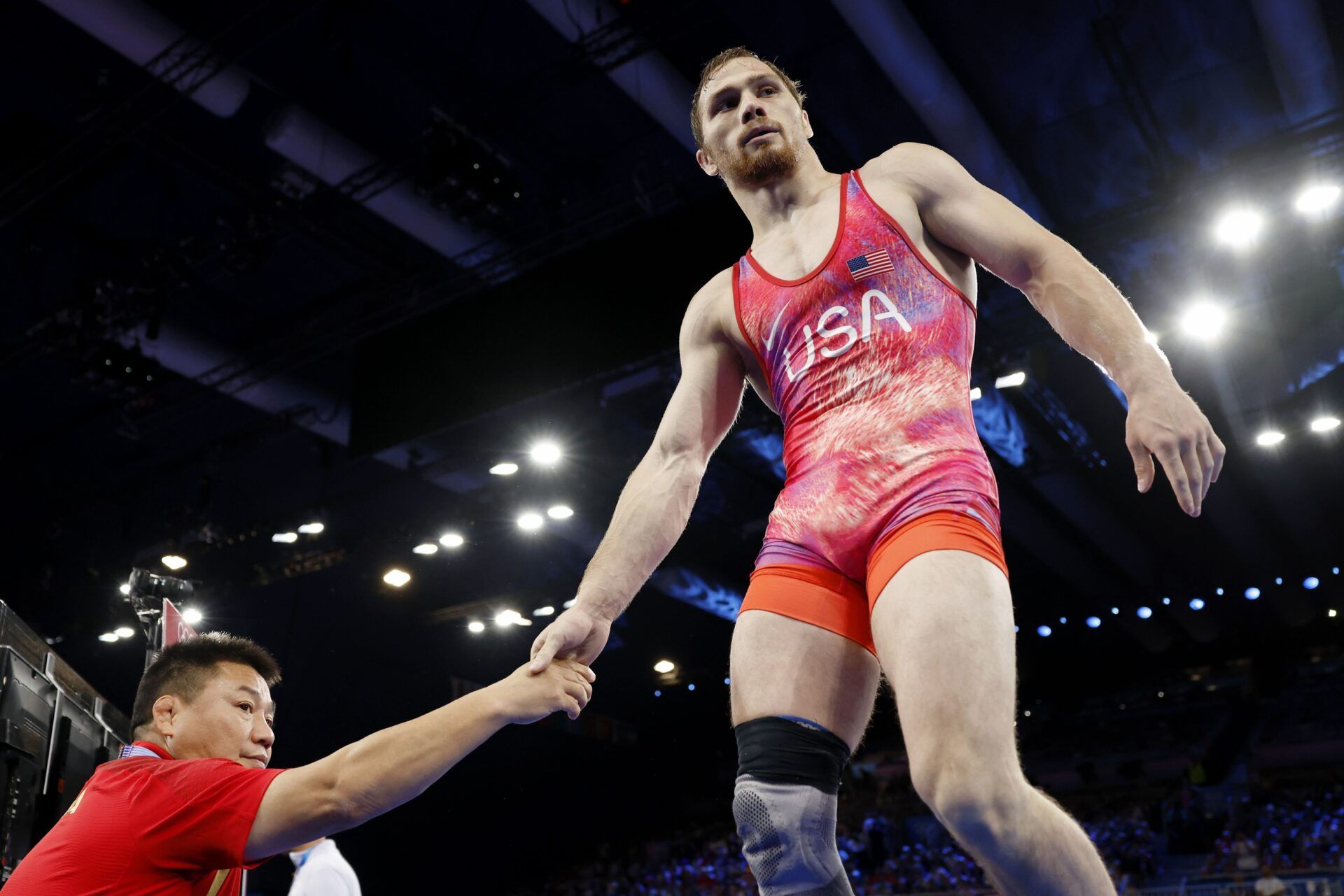 Spencer Richard Lee (USA) greets the coach of Wanhao Zou (CHN) after his win in a mens freestyle 57kg 1/8 final match during the Paris 2024 Olympic Summer Games at Champ-de-Mars Arena.