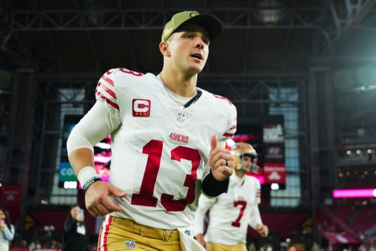 San Francisco 49ers quarterback Brock Purdy (13) runs off the field after defeating the Arizona Cardinals at State Farm Stadium.