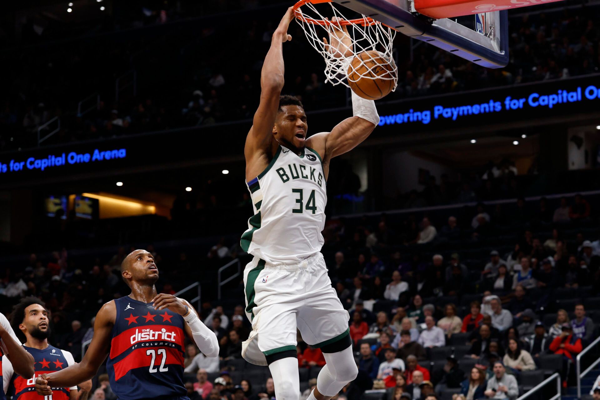Milwaukee Bucks forward Giannis Antetokounmpo (34) dunks the ball as Washington Wizards forward Khris Middleton (22) looks on in the second quarter at Capital One Arena.