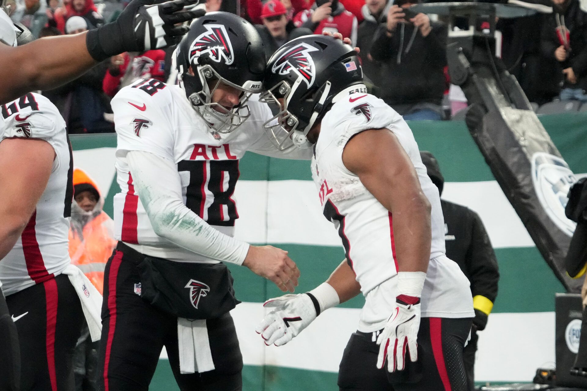 Atlanta Falcons running back Bijan Robinson (7) reacts with  quarterback Kirk Cousins (18) after a touchdown against the New York Jets during the first half at MetLife Stadium.