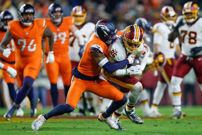 Denver Broncos cornerback Pat Surtain II (2) tackles Washington Commanders tight end Zach Ertz (86) in the first quarter of the game at Northwest Stadium.