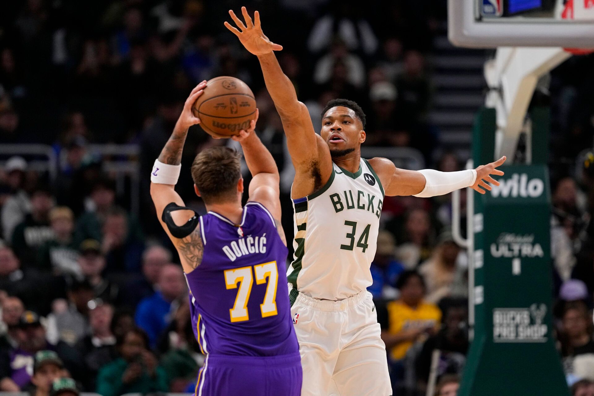 Milwaukee Bucks forward Giannis Antetokounmpo (34) defends Los Angeles Lakers guard Luka Doncic (77) during the first quarter at Fiserv Forum.