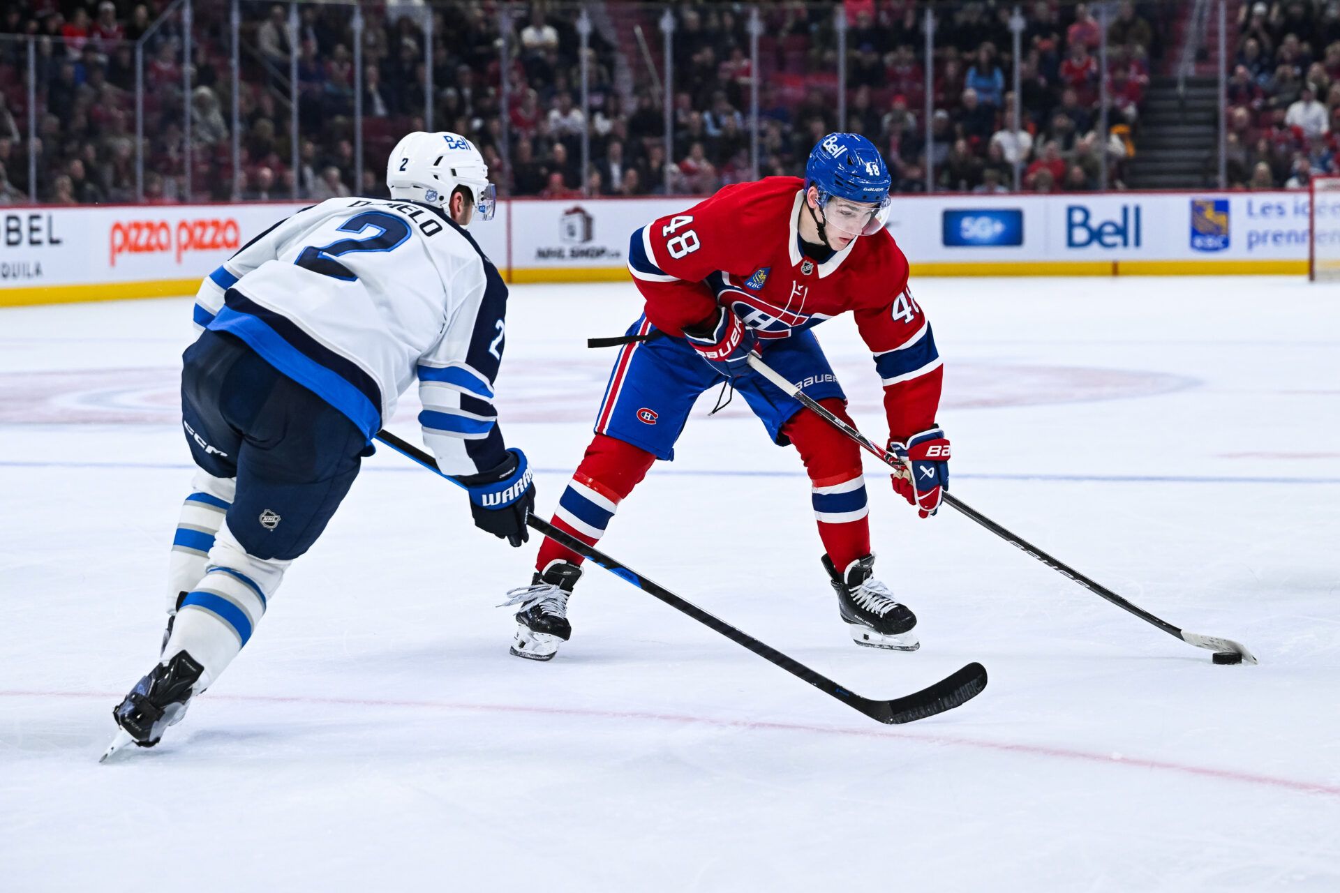 Montreal Canadiens defenseman Lane Hutson (48) plays the puck against Winnipeg Jets defenseman Dylan DeMelo (2) during the third period at Bell Centre.