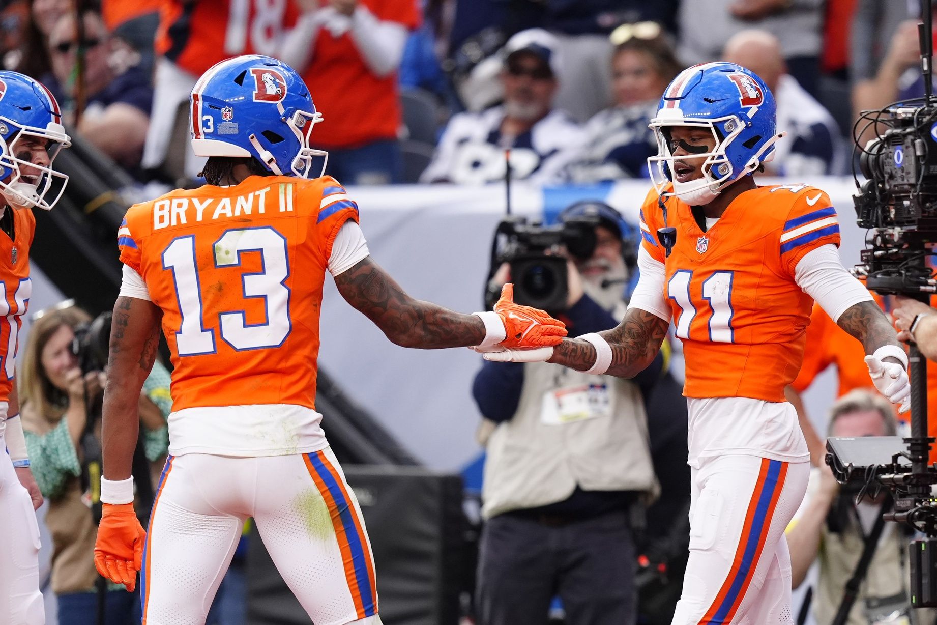 Denver Broncos wide receiver Troy Franklin (11) celebrates with wide receiver Pat Bryant (13) after scoring a touchdown against the Dallas Cowboys in the fourth quarter at Empower Field at Mile High.