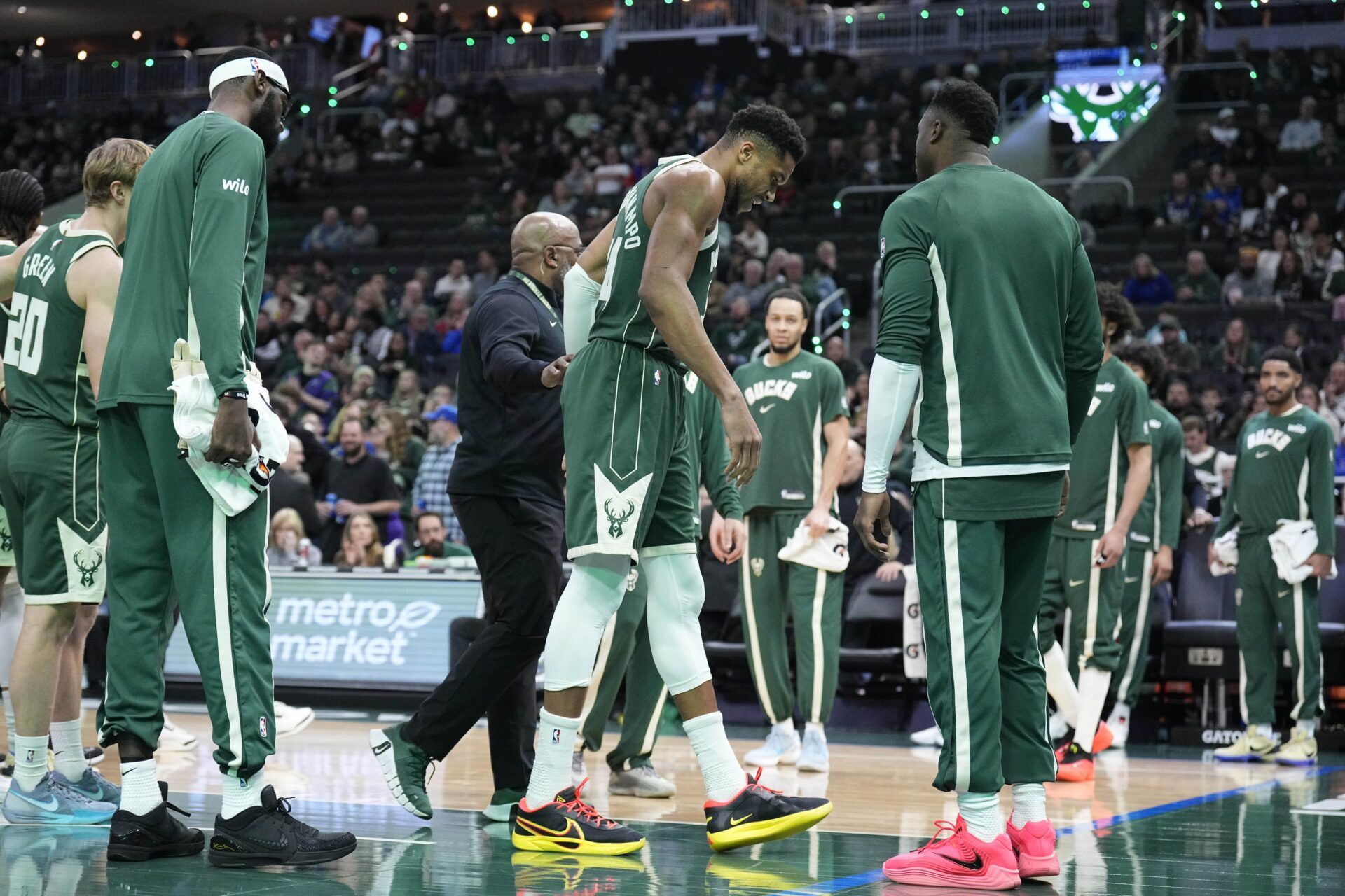 Milwaukee Bucks forward Giannis Antetokounmpo (34) grimaces as he limps off the court after going down with an injury in the first half against the Detroit Pistons at Fiserv Forum.