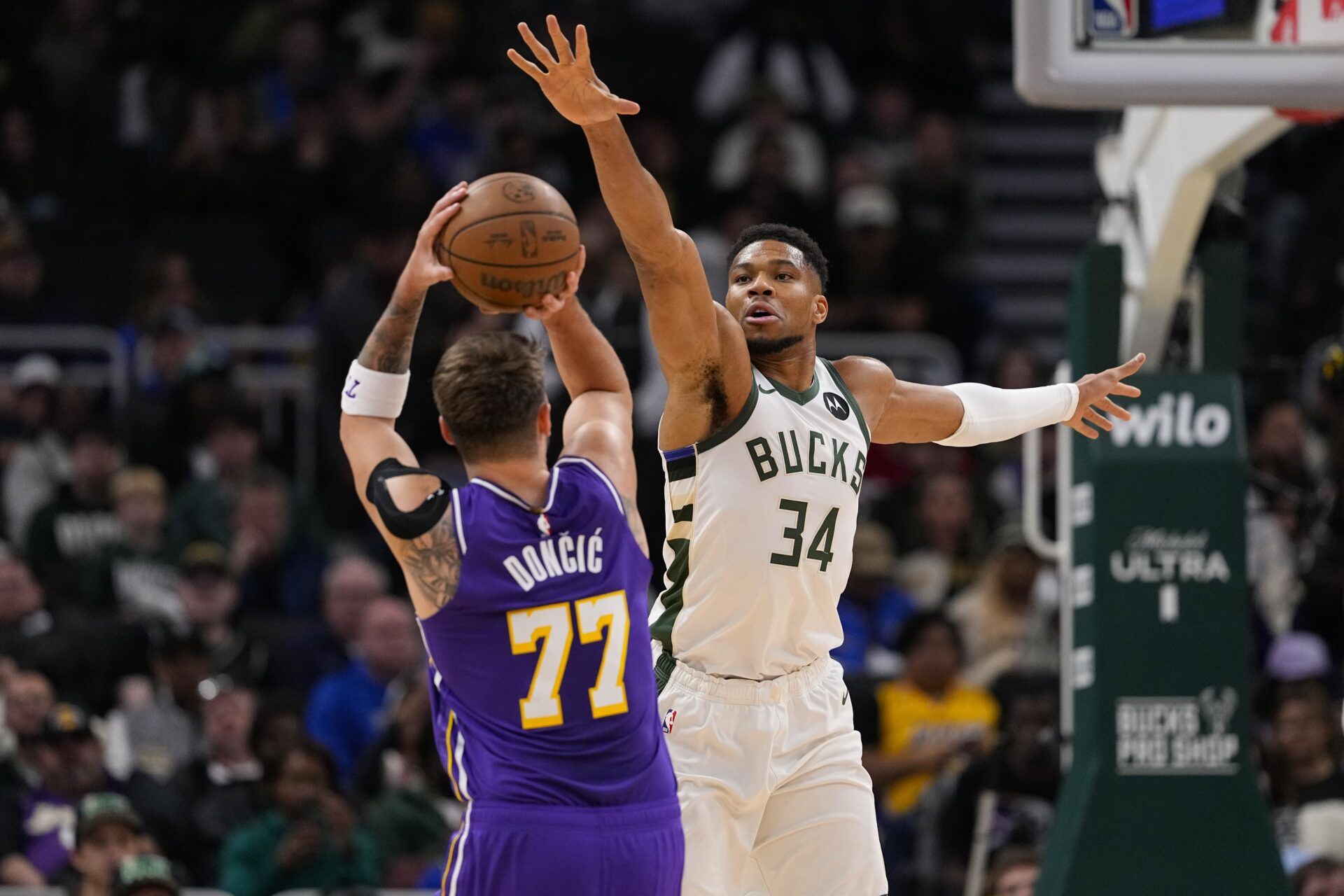 Milwaukee Bucks forward Giannis Antetokounmpo (34) defends Los Angeles Lakers guard Luka Doncic (77) during the first quarter at Fiserv Forum.
