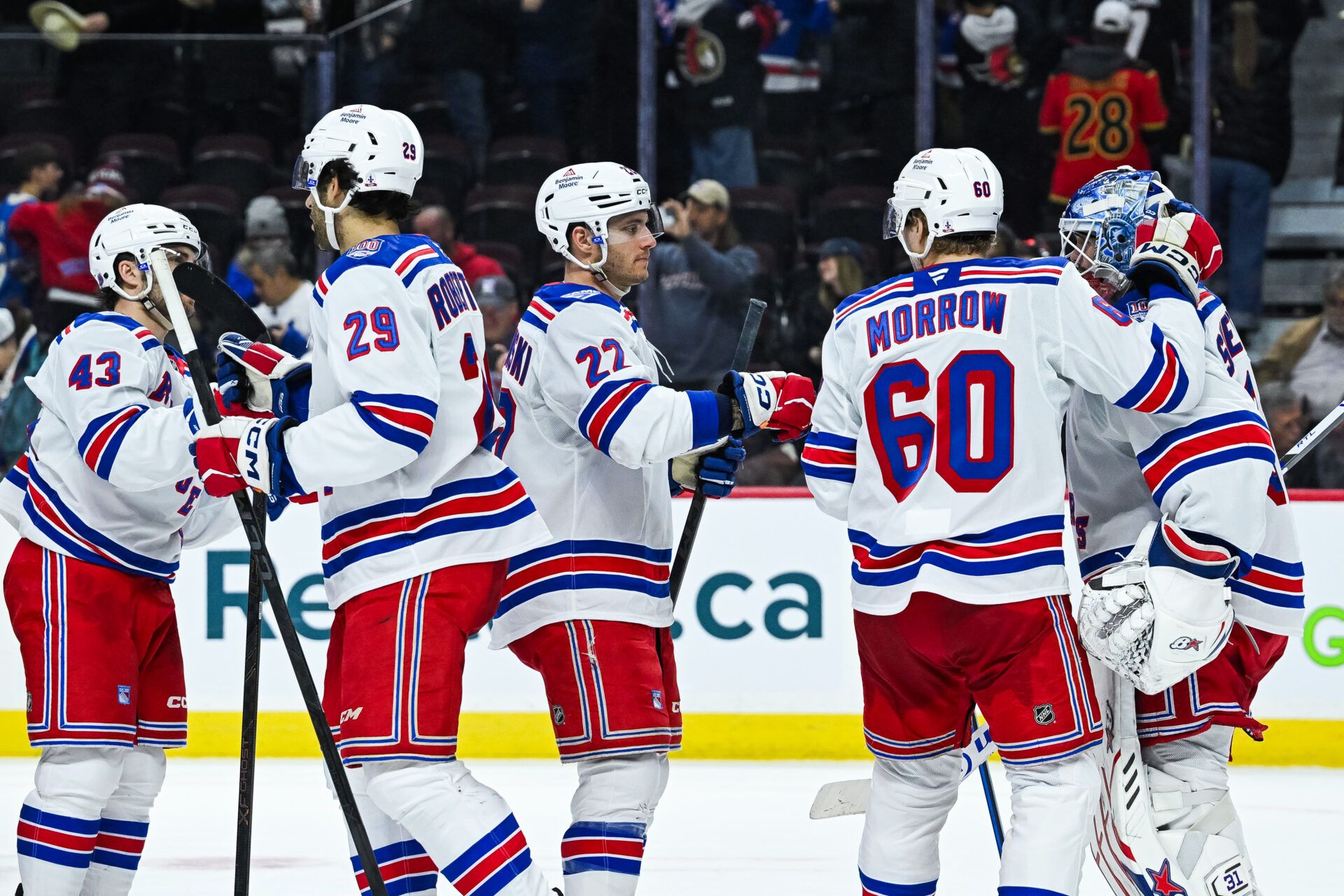New York Rangers players gather around goalie Igor Shesterkin (31) to celebrate their win against the Ottawa Senators at Canadian Tire Centre.