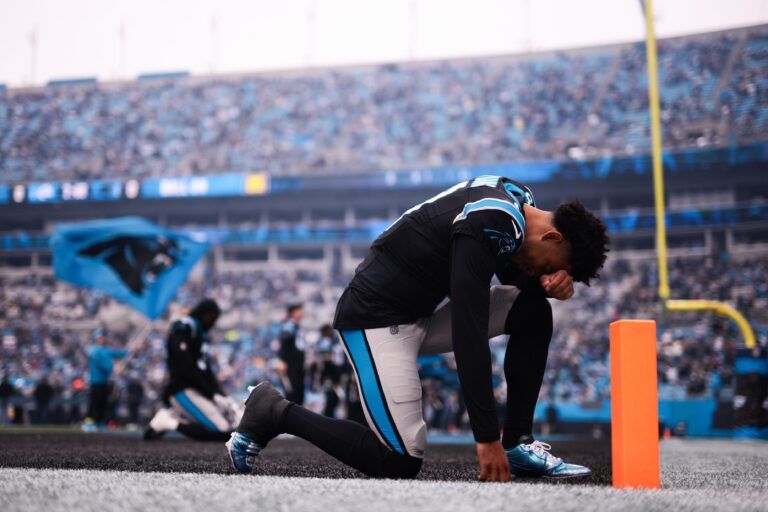 Carolina Panthers quarterback Bryce Young (9) kneels before the game against the Los Angeles Rams at Bank of America Stadium.