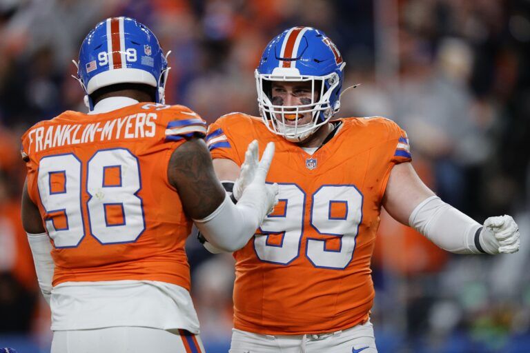Denver Broncos defensive end Zach Allen (99) reacts with defensive end John Franklin-Myers (98) during the first half at Empower Field at Mile High.