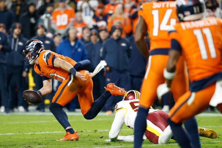 Denver Broncos quarterback Bo Nix (10) avoids a sack by Washington Commanders linebacker Preston Smith (52) in the second quarter of the game at Northwest Stadium.
