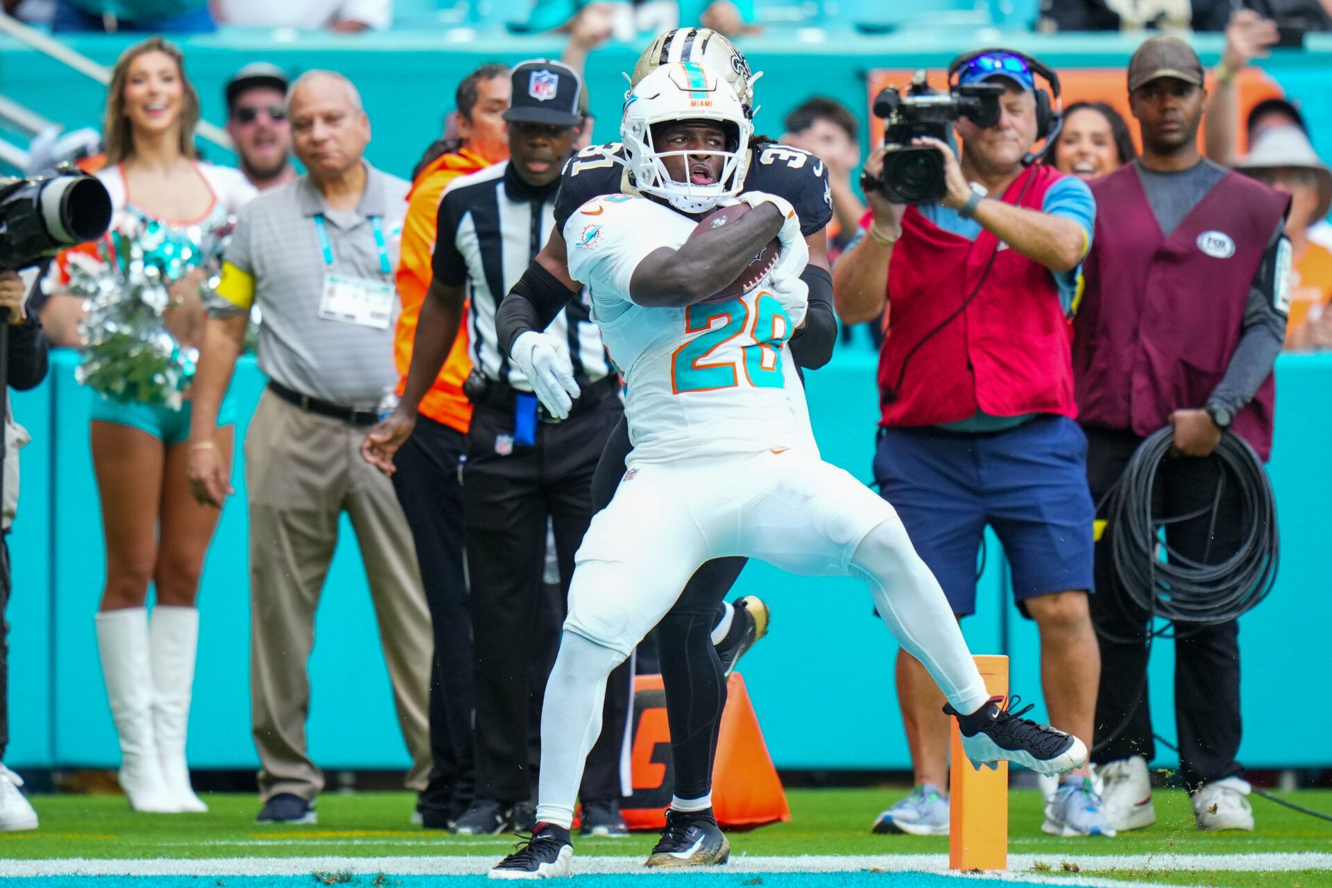 Miami Dolphins running back De'Von Achane (28) scores a touchdown as New Orleans Saints safety Jordan Howden (31) defends during the first half at Hard Rock Stadium.