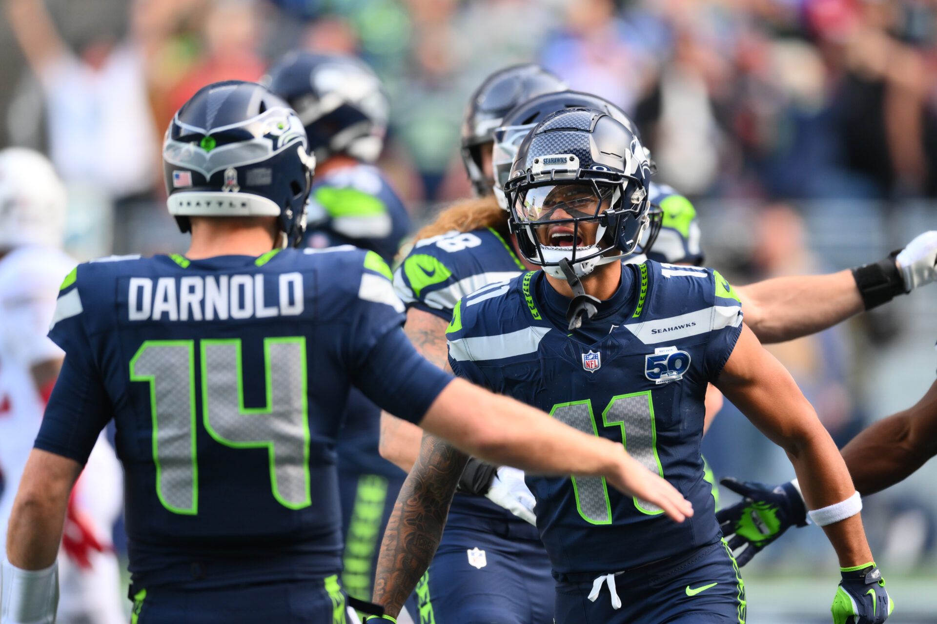 Seattle Seahawks wide receiver Jaxon Smith-Njigba (11) celebrates with Seattle Seahawks quarterback Sam Darnold (14) after scoring a touchdown during the first quarter against the Arizona Cardinals at Lumen Field.
