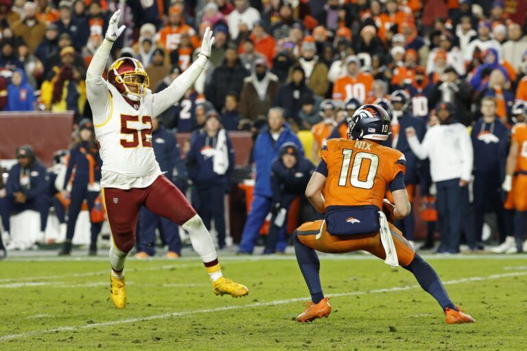 Denver Broncos quarterback Bo Nix (10) avoids the rush of Washington Commanders linebacker Preston Smith (52) in the third quarter at Northwest Stadium.